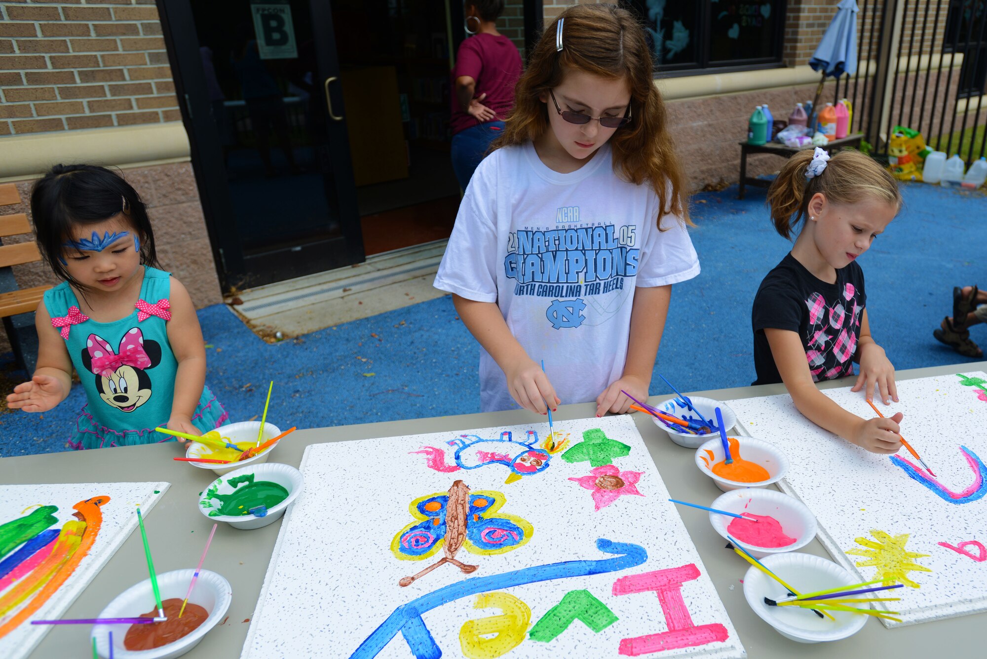 Team Shaw children decorate ceiling tiles from the McElveen Information and Learning Center during the End of Summer Reading Program Carnival at Shaw Air Force Base, S.C., Aug. 8, 2015. Once the paint dried the ceiling tiles were placed back inside the Children’s World area of the library. (U.S. Air Force photo by Airman 1st Class Kelsey Tucker/Released)