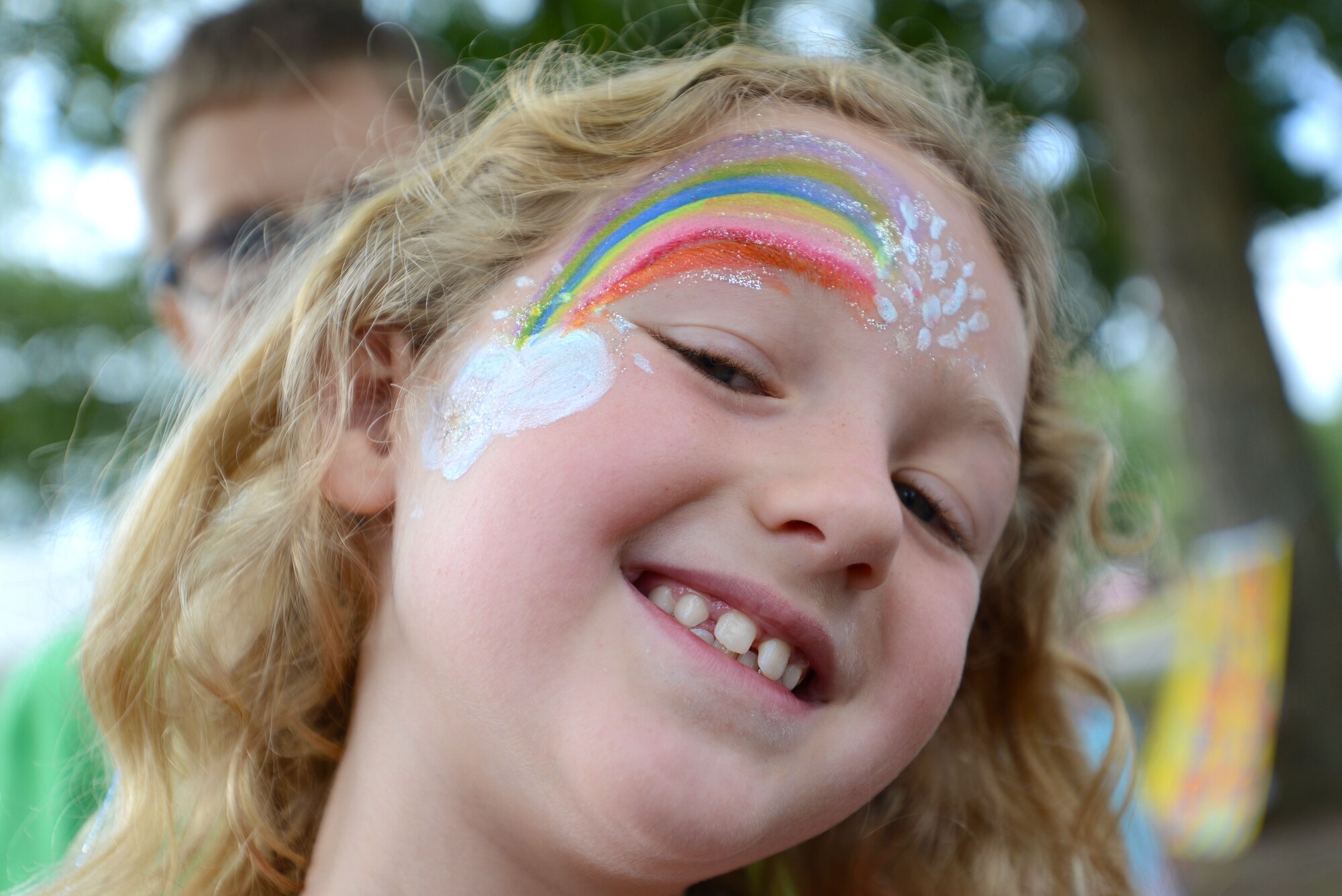 A Team Shaw child shows off her face paint at the End of Summer Reading Program Carnival in front of the McElveen Information and Learning Center at Shaw Air Force Base, S.C., Aug. 8, 2015. Along with face painting, the library personnel offered balloon animals, snacks, and a chance to dunk a librarian in the dunk tank. (U.S. Air Force photo by Airman 1st Class Kelsey Tucker/Released)