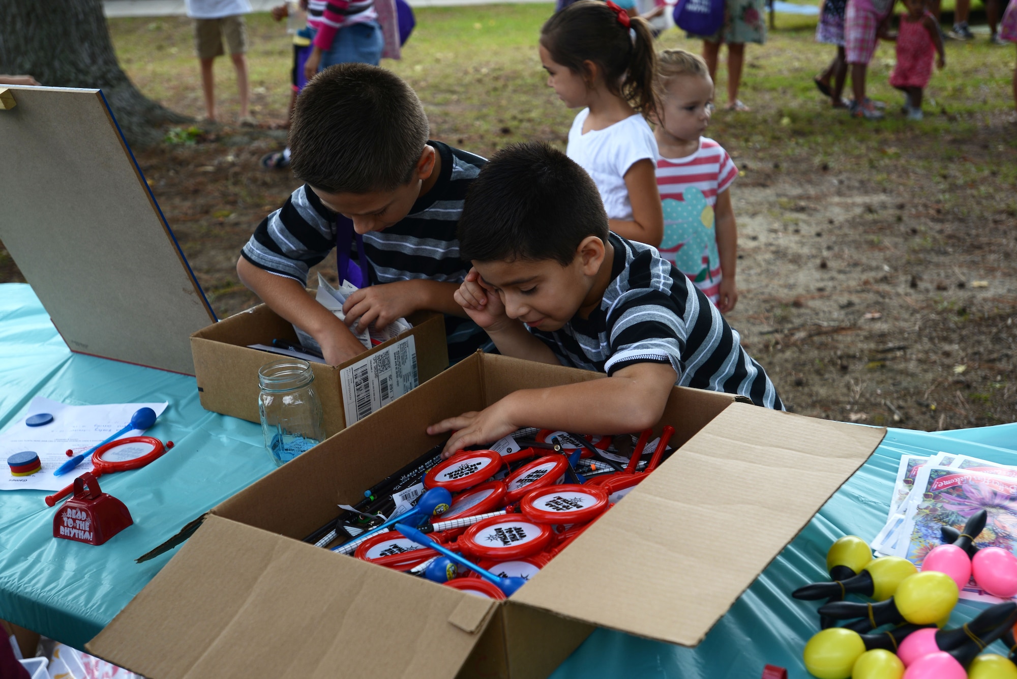 Team Shaw children dig through boxes of prizes at the End of Summer Reading Program Carnival in front of the McElveen Information and Learning Center at Shaw Air Force Base, S.C., Aug. 8, 2015. During the reading program, if children reached the final goal of 3,360 reading minutes, they were awarded a chance to dunk a librarian in the dunk tank. (U.S. Air Force photo by Airman 1st Class Kelsey Tucker/Released)