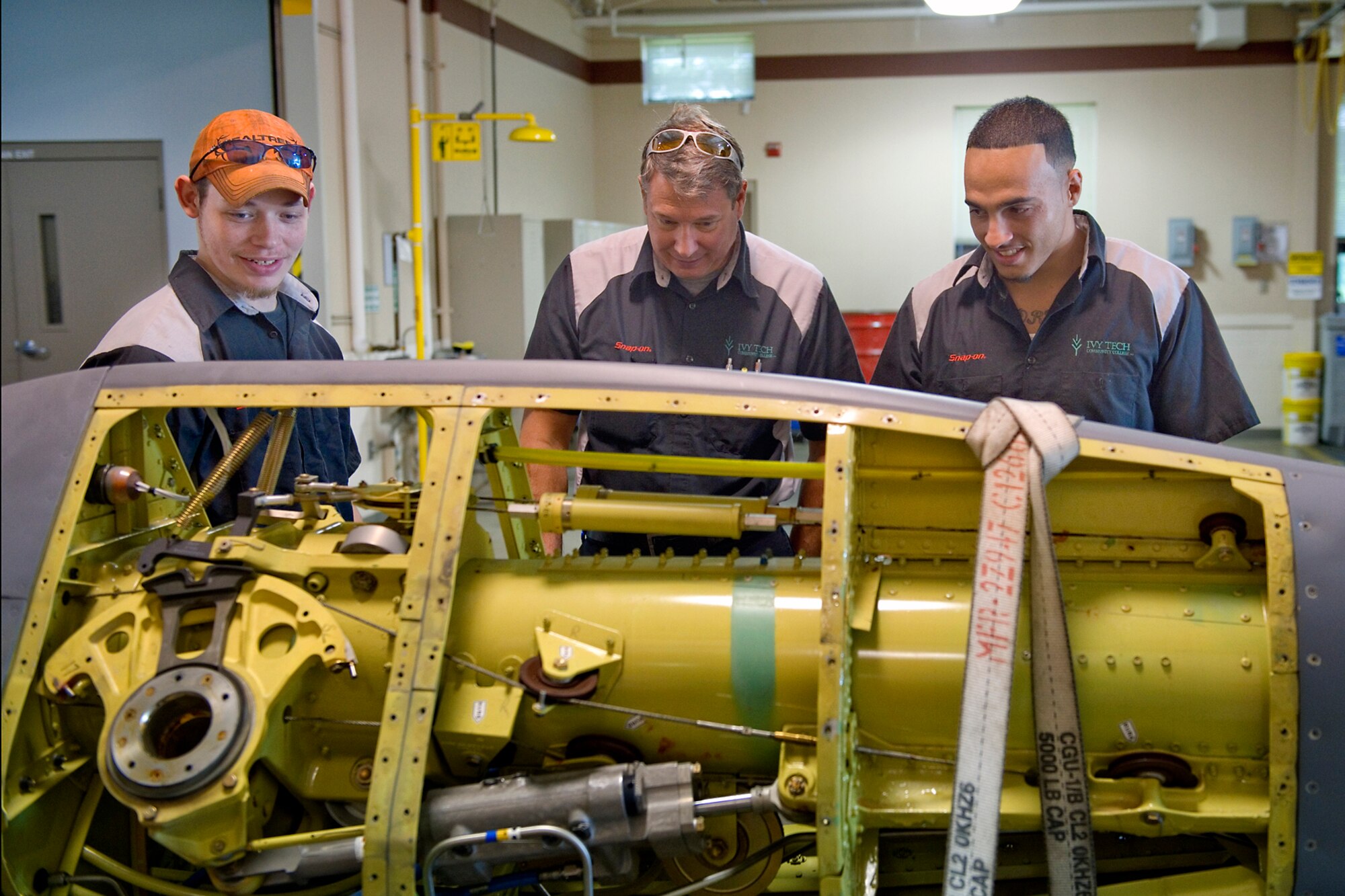 Jim Bonham, Ivy Tech Community College automotive instructor, center, and his students look at the mechanical components of a boom from a KC-135R Stratotanker during a tour at Grissom Air Reserve Base, Ind., July 22, 2015. During the tour the group visited Grissom's fabrication shop in addition to a KC-135R static display. (U.S. Air Force photo/Tech. Sgt. Benjamin Mota)