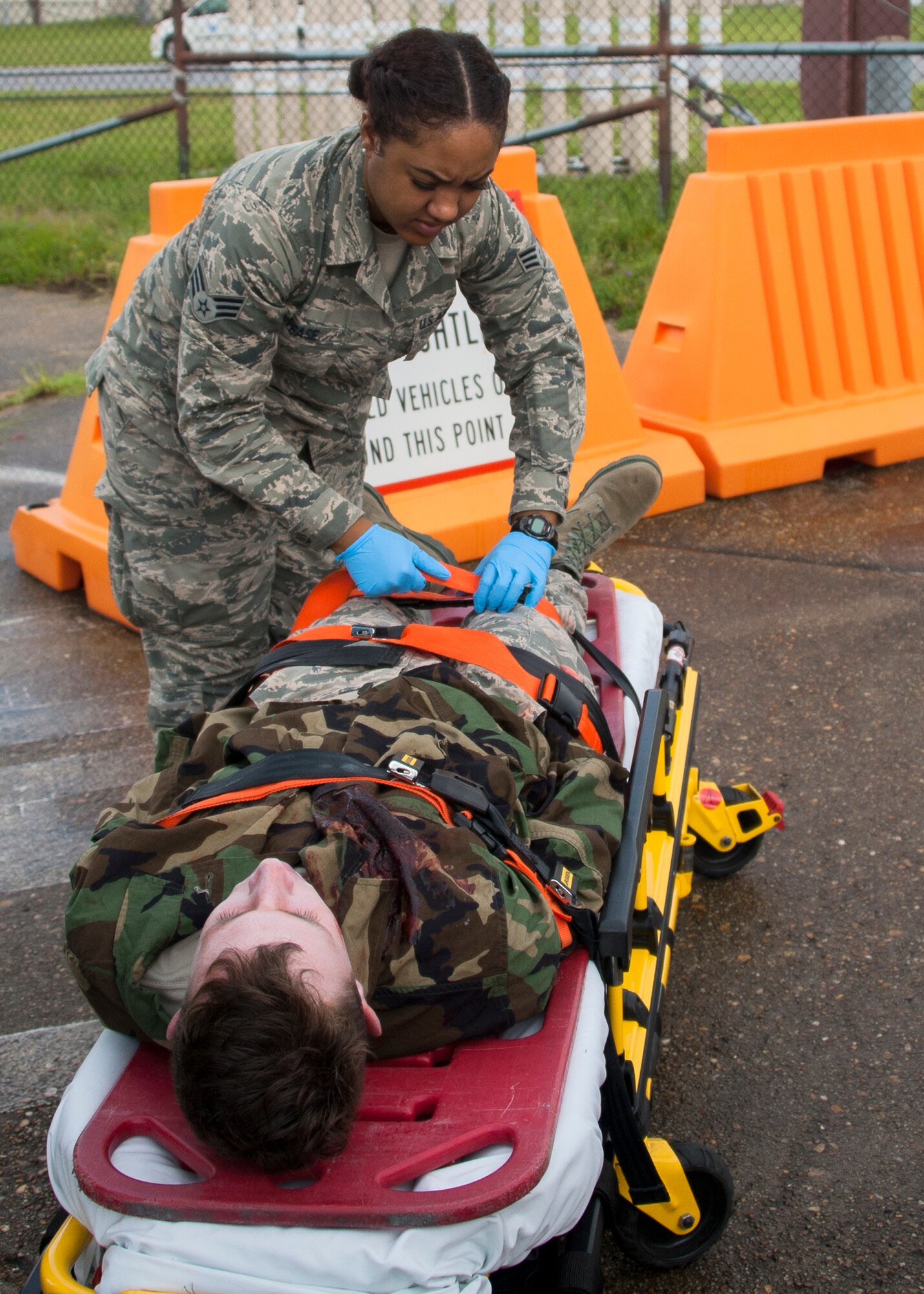 Senior Airman Leah Pease, 96th Aerospace Medicine Squadron, secures an injured victim to a gurney during a simulated aircraft hijacking scenario as part of the 96th Test Wing’s force protection condition exercise Aug. 6 at Eglin Air Force Base, Fla.  The FPCON exercise tested the base’s first responders’ rescue skills while the simulated hijacker was apprehended and the injured were moved to safety for treatment. (U.S. Air Force photo/Ilka Cole)