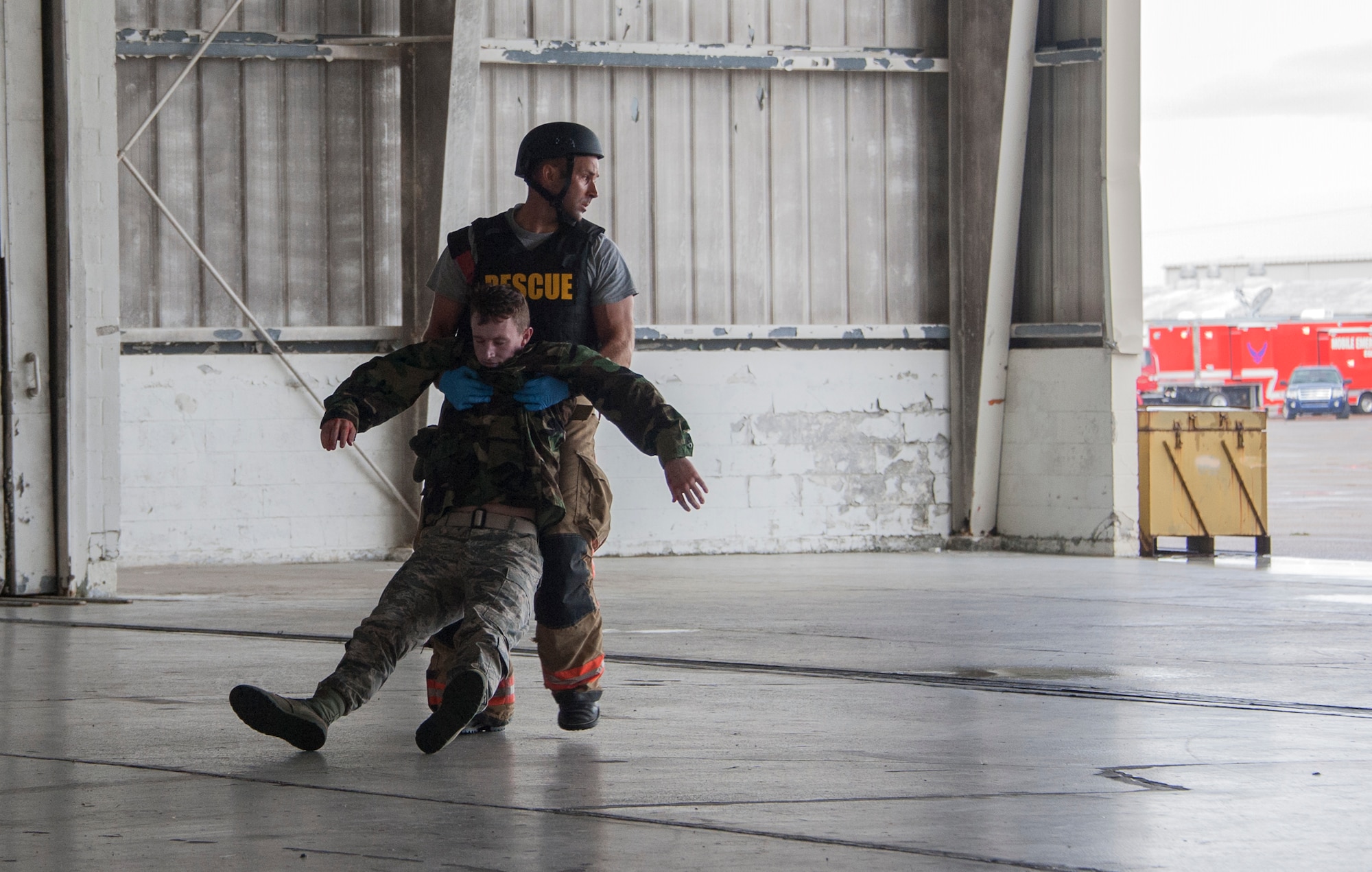 An Eglin fireman carries Senior Airman Ryan Edmonds, 96th Mission Support Group, to safety during a simulated aircraft hijacking scenario as part of the 96th Test Wing’s force protection condition exercise Aug. 6 at Eglin Air Force Base, Fla.  The FPCON exercise tested the base’s first responders’ rescue skills while the simulated hijacker was apprehended and the injured were moved to safety for treatment. (U.S. Air Force photo/Ilka Cole)