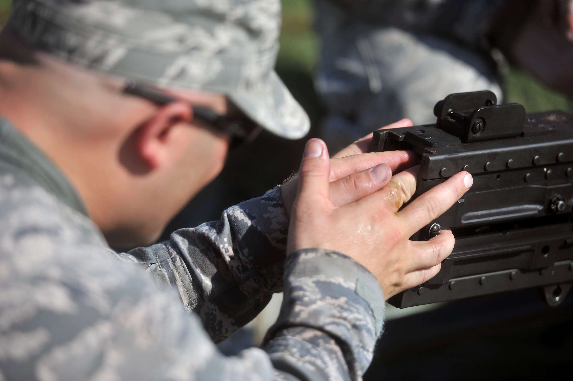 FORT SILL, Okla. – U.S. Air Force Staff Sgt. Joseph Sewell, 97th Security Forces Squadron Combat Arms Training and Maintenance instructor, adjusts the timing on a M2 machine gun before firing at the Kerr Hill Machine Gun Range, Aug. 7, 2015. Members from the 97th SFS and 82nd SFS trained together to qualify and maintain M2 certifications. (U.S. Air Force photo by Senior Airman Dillon Davis/Released)