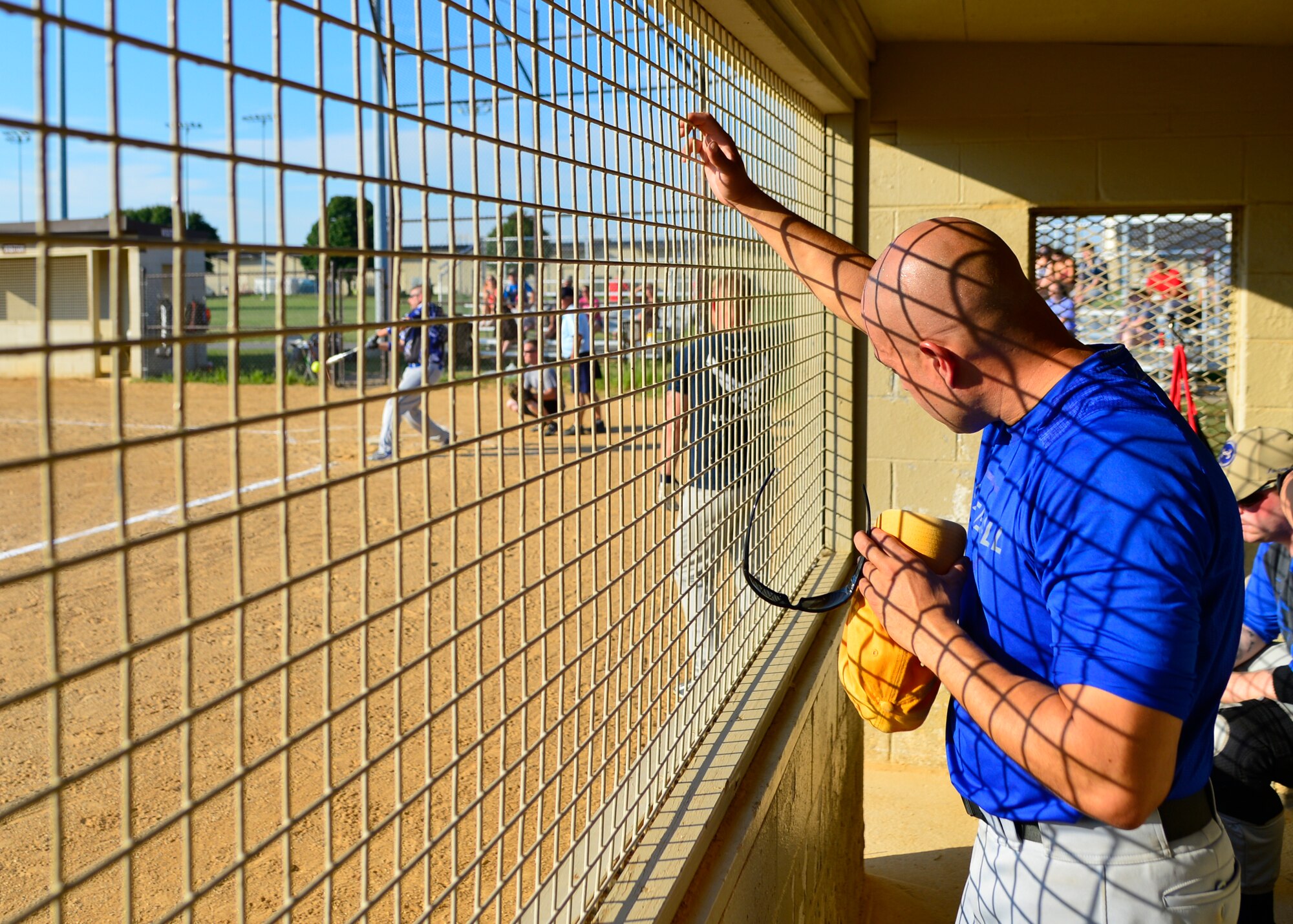 Scott Hautanen, 436th Security Forces Squadron right fielder, watches from the dugout as his teammate, Rick Barker, 436th SFS assistant coach, hits a softball during an intramural softball game against the 436th Aircraft Maintenance Squadron Aug. 3, 2015, at the softball field on Dover Air Force Base, Del. The 436th SFS scored three runs in the seventh inning, winning the game, 8-7. (U.S. Air Force  photo/Airman 1st Class William Johnson)