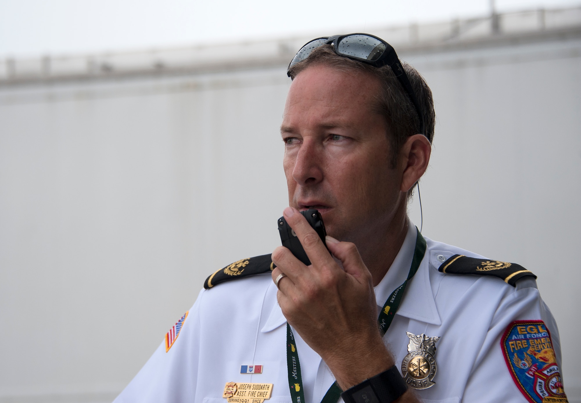 Joseph Suddarth, a 96th Civil Engineer Squadron assistant fire chief, communicates and coordinates with exercise planners and first responders during a simulated aircraft hijacking scenario as part of the 96th Test Wing’s force protection condition exercise Aug. 6 at Eglin Air Force Base, Fla.  The FPCON exercise tested the base’s first responders’ rescue skills while the simulated hijacker was apprehended and the injured were moved to safety for treatment. (U.S. Air Force photo/Ilka Cole)