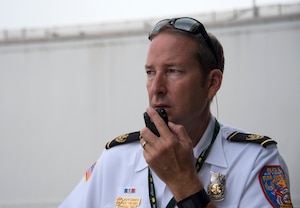 Joseph Suddarth, a 96th Civil Engineer Squadron assistant fire chief, communicates and coordinates with exercise planners and first responders during a simulated aircraft hijacking scenario as part of the 96th Test Wing’s force protection condition exercise Aug. 6 at Eglin Air Force Base, Fla.  The FPCON exercise tested the base’s first responders’ rescue skills while the simulated hijacker was apprehended and the injured were moved to safety for treatment. (U.S. Air Force photo/Ilka Cole)
