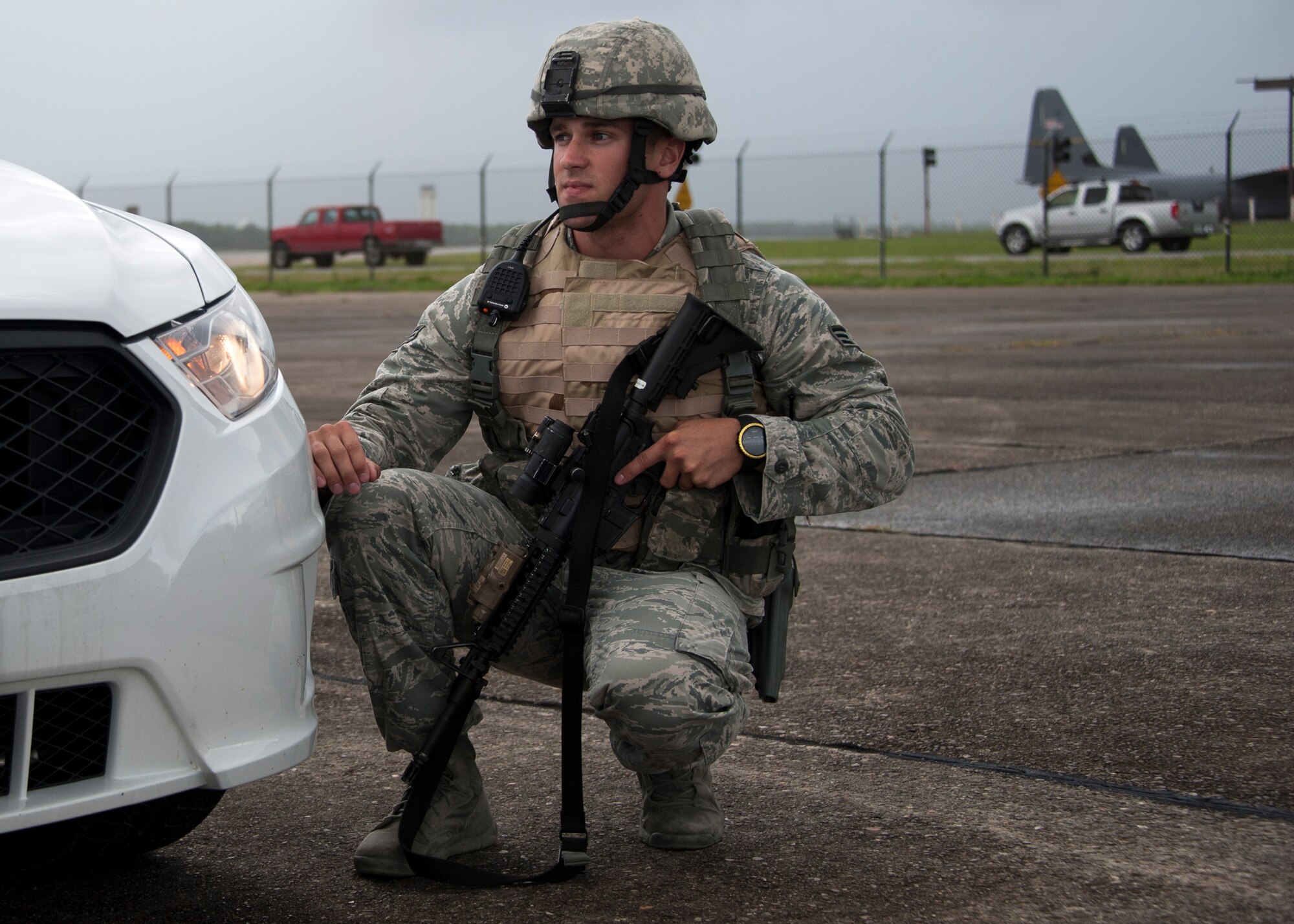 Senior Airman Nathan Koenig, 96th Security Forces Squadron, crouches behind his patrol car during a simulated aircraft hijacking scenario as part of the 96th Test Wing’s force protection condition exercise Aug. 6 at Eglin Air Force Base, Fla.  The FPCON exercise tested the base’s first responders’ rescue skills while the simulated hijacker was apprehended and the injured were moved to safety for treatment. (U.S. Air Force photo/Ilka Cole)