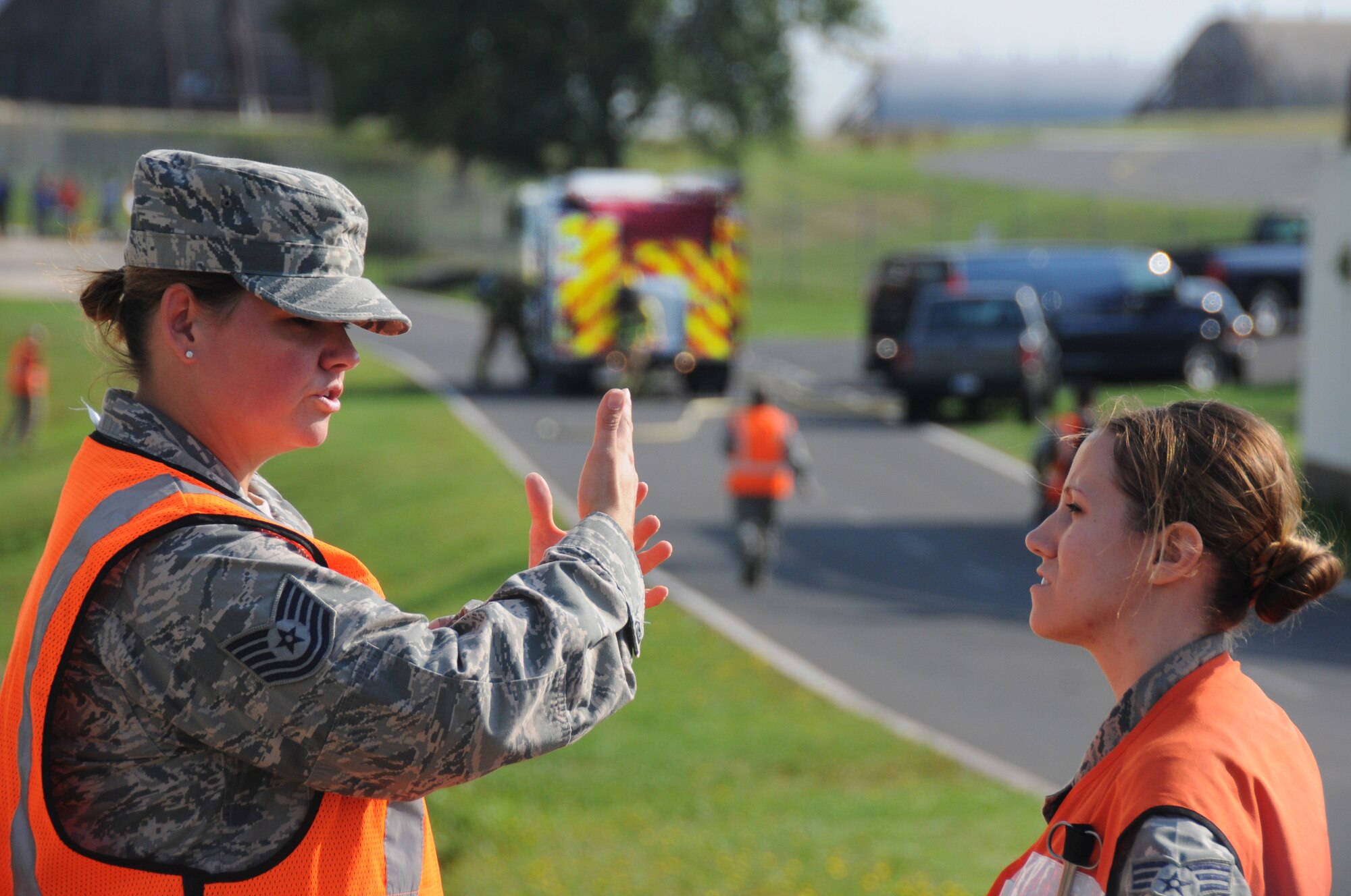 A picture of U.S. Air Force Tech. Sgt. Melissa Blackledge and Senior Airman Melissa Seel, aerospace medical technicians from the New Jersey Air National Guard's 177th Medical Group, discussing operation strategy during a simulated fuel spill.
