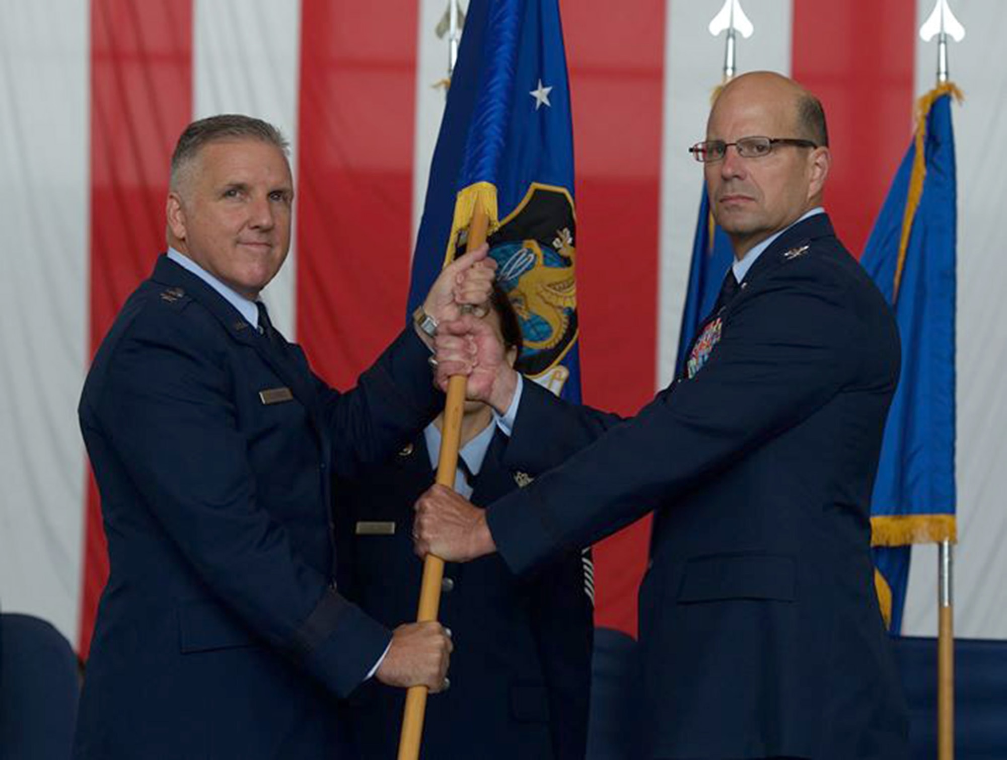 Maj. Gen. John C. Flournoy, Jr., Commander, 4th Air Force, passes the flag of the 349th Air Mobility Wing to Col. Raymond A. Kozak in a change of command ceremony at Travis Air Force Base, Calif., Aug. 8, 2015. Kozak will lead more than 3,100 combat-ready Citizen Airmen, flying and maintaining the C-17 Globemaster III, C-5 Galaxy and KC-10 Extender mobility aircraft. (U.S. Air Force photo/Ken Wright)