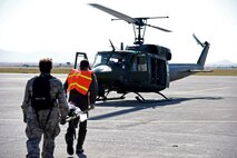 Airmen transport a simulated natural disaster victim to a UH-1N Huey helicopter on the flightline at Malmstrom Air Force Base, Mont., Aug. 10, 2015, as part of a Major Accident Response Exercise. Forty-two victims of a simulated building collapse were air lifted to a virtual triage center in downtown Great Falls and Helena, Mont., approximately 90 miles away. (U.S. Air Force photo/Airman 1st Class Collin Schmidt)