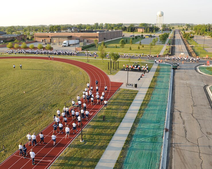 Airmen position themselves behind the staring line to start a two-mile run during a wing run event on August 6, 2015, on Grand Forks Air Force Base, N.D.  The Warriors of the North ran together to promote the physical pillar of the Comprehensive Airman Fitness Program. (U.S. Air Force photo by Senior Airman Xavier Navarro/released)