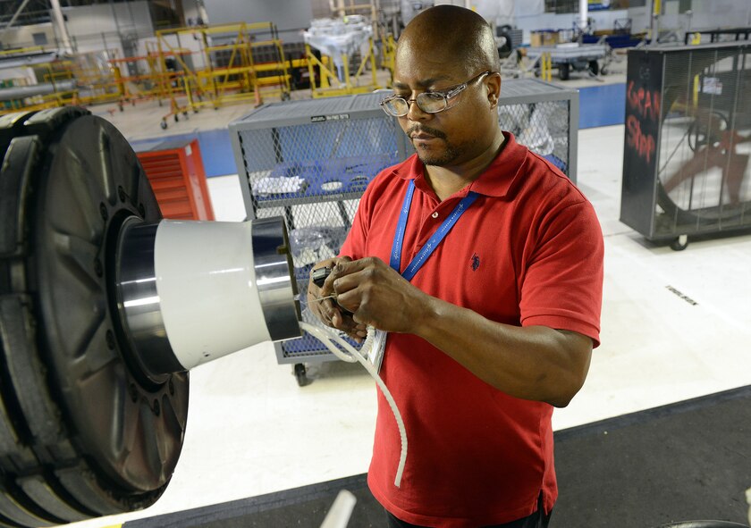 Alonzo Ellis, 569th Aircraft Maintenance Squadron aircraft electrician, installs a C-5 landing gear wiring harness at Robins Air Force Base. The enormous C-5 Galaxy has a very unique landing gear system consisting of a single nose strut, four main bogeys and a total of 28 wheels. The landing gear system also has the capability of raising each set of wheels individually for simplified tire changes or brake maintenance. (U.S. Air Force photo by Tommie Horton)