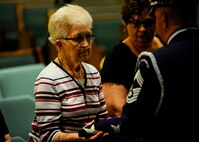 Verna Welsh receives a flag from a member of the 184th Intelligence Wing Honor Guard, Aug. 10, 2015, in Wichita, Kan. Welsh is the final surviving sibling of Staff Sgt. Dale Francis and Pfc. Paul Edward Kingsley, who died in 1943 and 1944 respectively, while serving in World War II. The memorial flag for each of her brothers was refolded during a ceremony in honor of the two brothers, who were Kansans by birth. (U.S. Air Force photo by Senior Airman Victor J. Caputo)