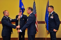 Col. Kurt Matthews, the 919th Special Operations Group commander, left, hands the 2nd Special Operations Squadron guidon to its new commander, Lt. Col. Eric Kos, during a change of command ceremony at Hurlburt Field, Fla., Aug. 3.  Kos replaced Lt. Col. Randal Russell, right, at the 919th Special Operations Wing unit which operates the MQ-9 Reaper remotely piloted aircraft for combatant commanders worldwide. (U.S. Air Force photo/Amn. Kai White)