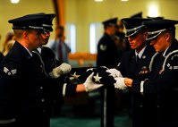 Honor guardsmen from the 22nd Air Refueling Wing and 184th Intelligence Wing fold an American Flag, Aug. 10, 2015, in Wichita, Kan. Two flags from 1943 and 1944 were refolded at the request of Verna Welsh, the last surviving sibling of Staff Sgt. Dale Francis and Pfc. Paul Edward Kingsley, who died in World War II. (U.S. Air Force photo by Senior Airman Victor J. Caputo)