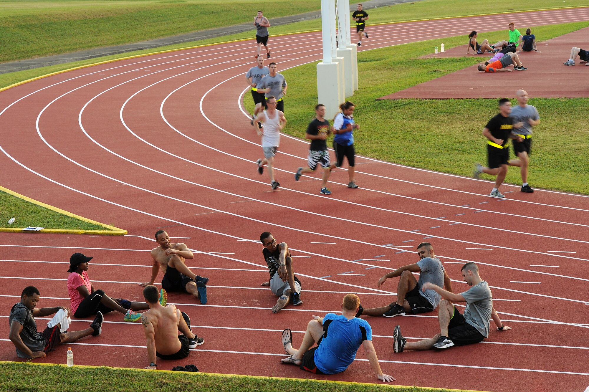 Several small groups of participants in the first session of Kadena Air Base’s running improvement program work out and perform post-run stretches on the Kadena High School track, Aug. 5, 2015. The running improvement program is an eight-week program designed to improve particpants’ run times while educating them on proper form. Historically, participants average a 1 minute 45 second improvement on their one and a half mile timed run. (U.S. Air Force photo by Airman 1st Class Zade C. Vadnais) 