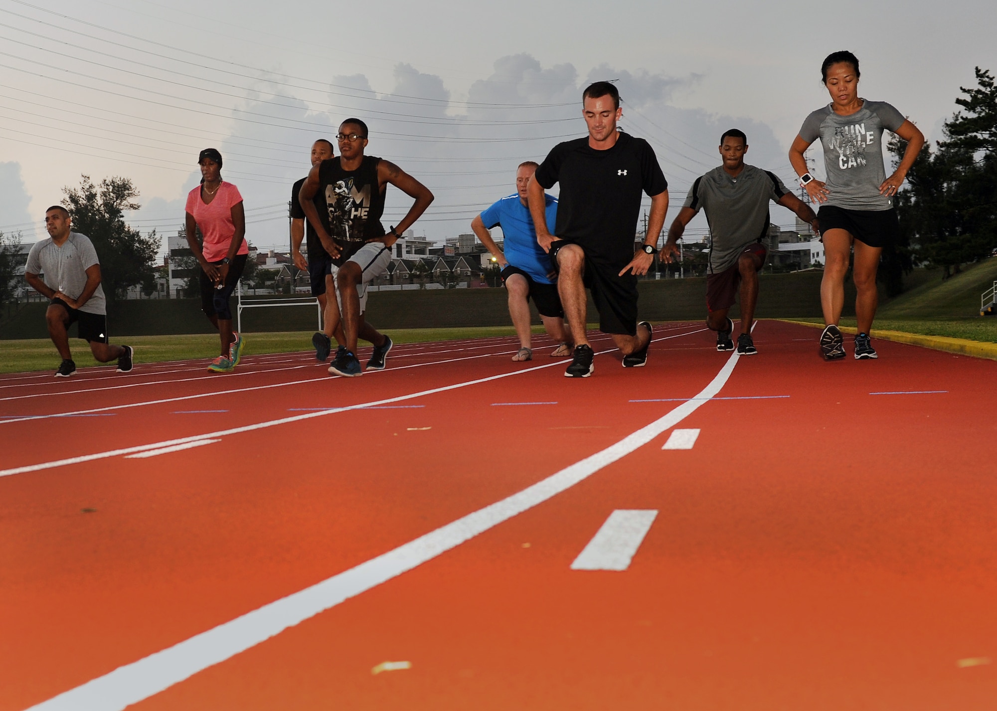 Participants in the first session of Kadena Air Base’s running improvement program perform lunges as a warm up exercise before beginning their cardiovascular workout at the Kadena High School track, Aug. 5, 2015. The running improvement program is an eight-week program designed by a certified natural running coach that aims to improve participants’ run times while educating them on proper form. (U.S. Air Force photo by Airman 1st Class Zade C. Vadnais)
