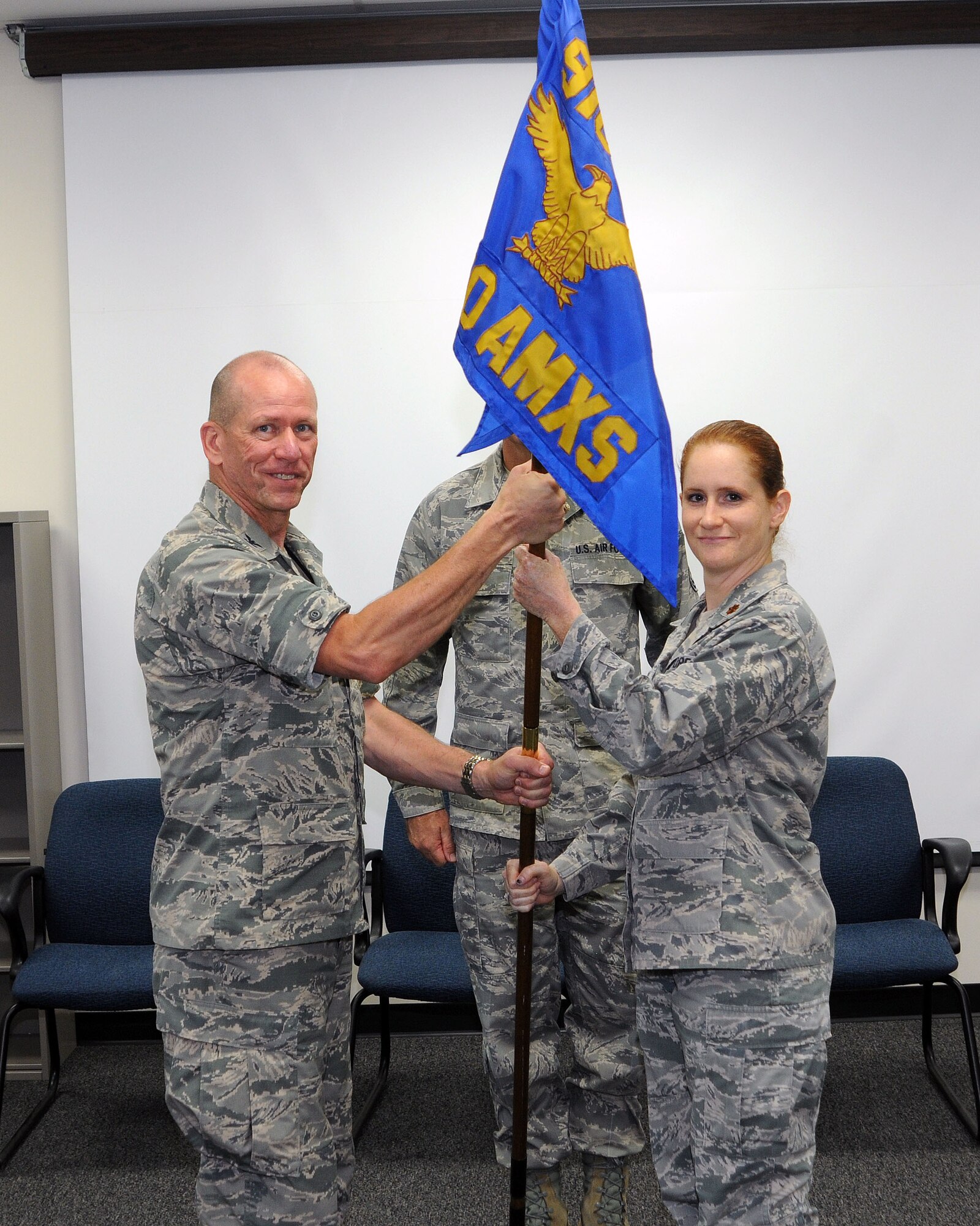 910th Maintenance Group Commander Col. David Post and 910th Aircraft Maintenance Squadron Commander Maj. Catherine Correa pose for a photo while Correa receives the squadron guidon. Correa assumed command of the Aircraft Maintenance Squadron during a ceremony here, July 31, 2015. (U.S. Air Force photo/Tech. Sgt. Rick Lisum)