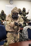 An Airman tightens the seal around his gloves during a chemical, biological, radiological and nuclear warfare training class hosted by 502nd Civil Engineer Squadron emergency management specialists Aug. 6 at Joint Base San Antonio-Randolph.