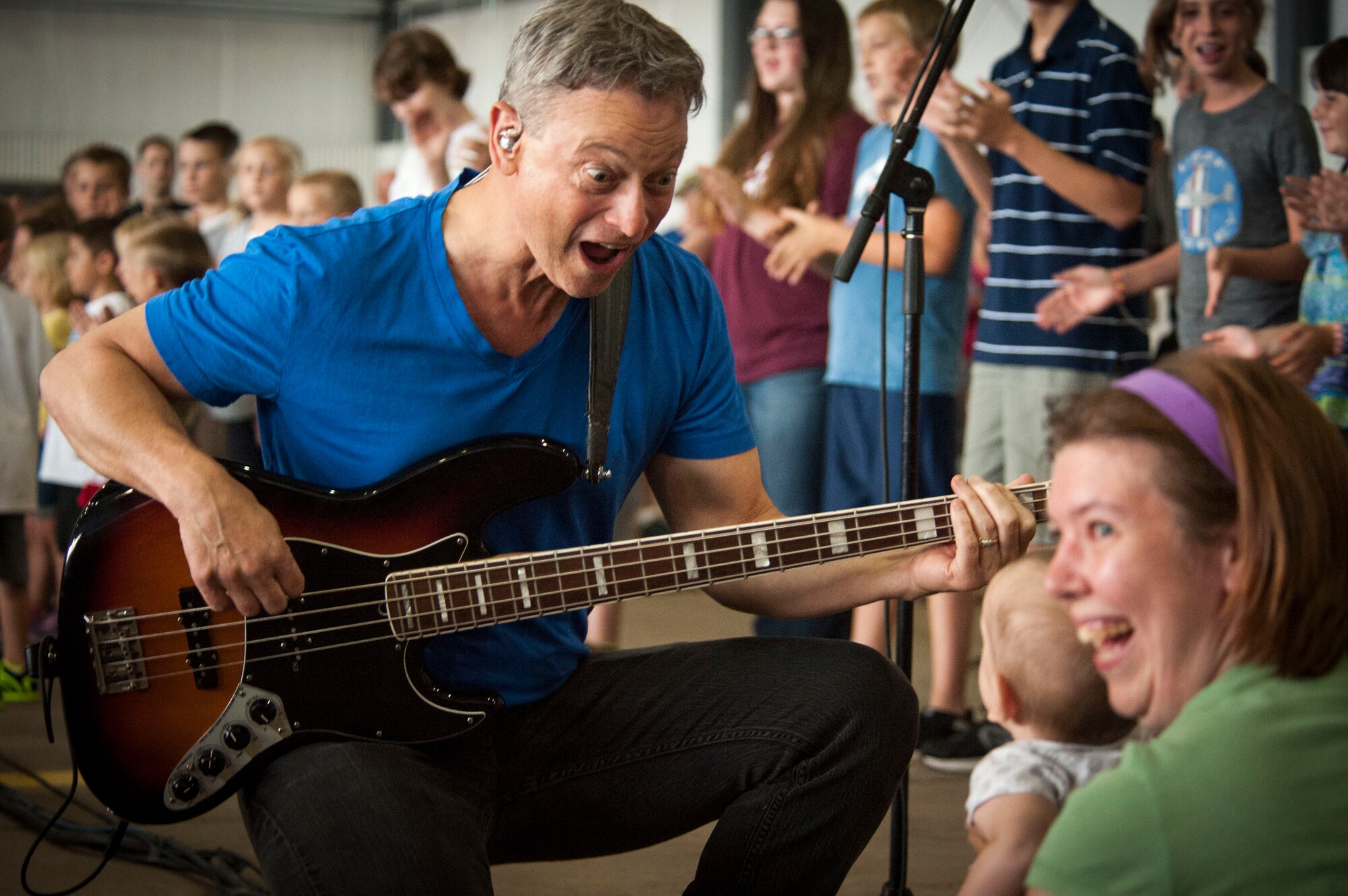 Gary Sinise a member of the Lt. Dan Band, interacts with a chid in the audience during a performance at the 2015 Canon Open House, Aug. 8, 2015 at Cannon Air Force Base, N.M. The Lt. Dan Band and local musical artists provided entertainment during the free event that was open military and civilians . (U.S. Air Force photo/Master Sgt. Phyllis Keith)