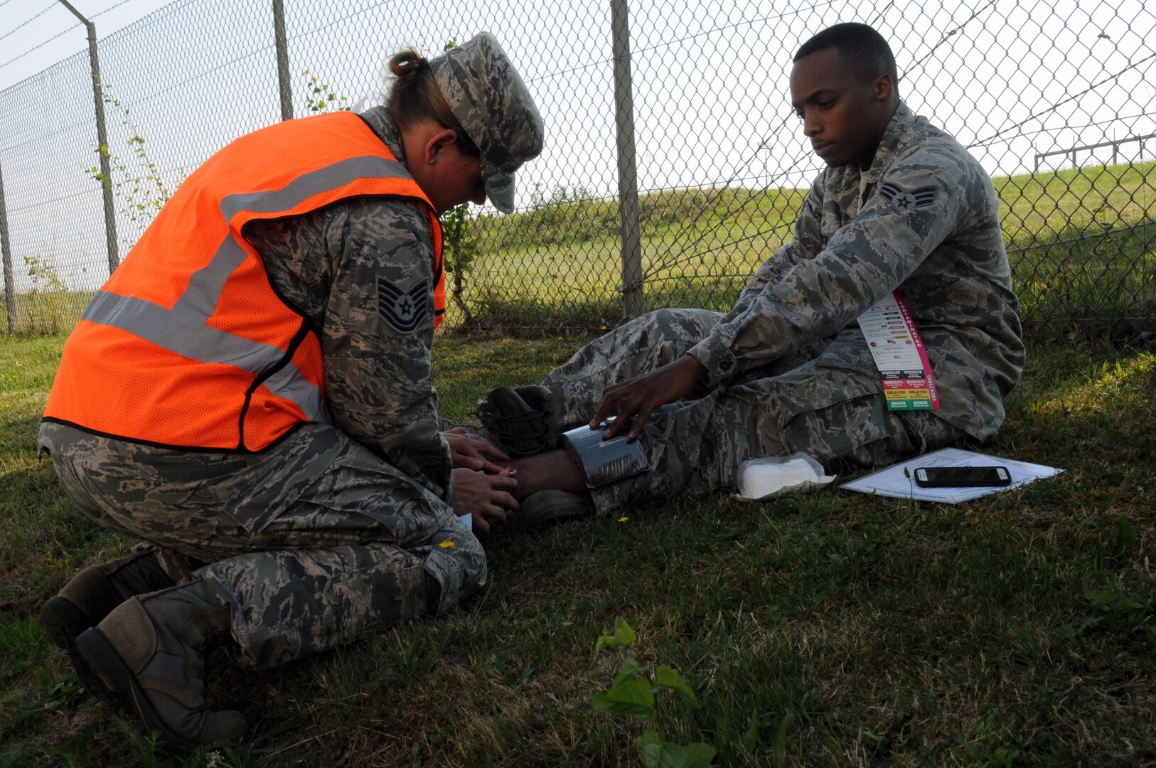 U.S. Air Force Tech. Sgt. Melissa Blackledge, an aerospace medical technician from the New Jersey Air National Guard's 177th Medical Group, assists a mock patient with a broken ankle during a simulated fuel spill on Spangdahlem Air Base, Germany, Aug. 7, 2015. Blackledge was embedded as part of the wing-inspection team for the scenario-based inspection. 