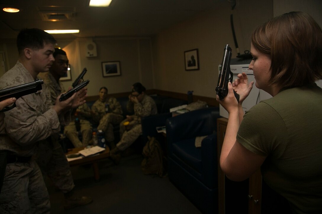 INDIAN OCEAN (July 23, 2015) U.S. Marine Cpl. Alexandra Beggio, right, demonstrates an immediate-action pistol drill aboard the amphibious assault ship USS Essex (LHD 2). Beggio is a member of the 15th Marine Expeditionary Unit’s Female Engagement Team and a field radio operator with Marine Medium Tiltrotor Squadron 161 (Reinforced), 15th MEU. The FET taught pistol marksmanship to a group of inexperienced Marines to become more confident in their teaching skills. The 15th MEU is embarked on the Essex Amphibious Ready Group and deployed to maintain regional security in the U.S. 5th Fleet area of operations. (U.S. Marine Corps photo by Cpl. Anna Albrecht/Released)