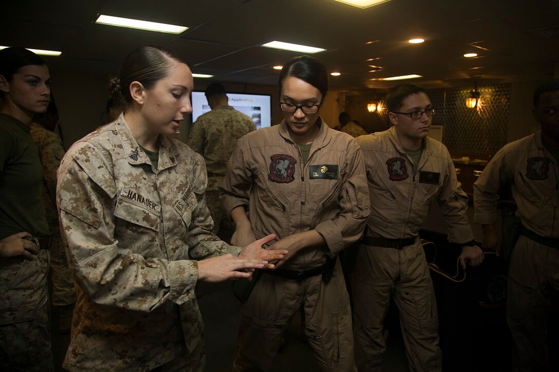 INDIAN OCEAN (July 23, 2015) U.S. Marine Cpl. Anastacia Hanauer, left, explains pistol fundamentals aboard the amphibious assault ship USS Essex (LHD 2). Hanauer is a member of the 15th Marine Expeditionary Unit’s Female Engagement Team and a data technician with the 15th MEU’s Command Element. The FET taught pistol marksmanship to a group of inexperienced Marines to become more confident in their teaching skills. The 15th MEU is embarked on the Essex Amphibious Ready Group and deployed to maintain regional security in the U.S. 5th Fleet area of operations. (U.S. Marine Corps photo by Cpl. Anna Albrecht/Released)