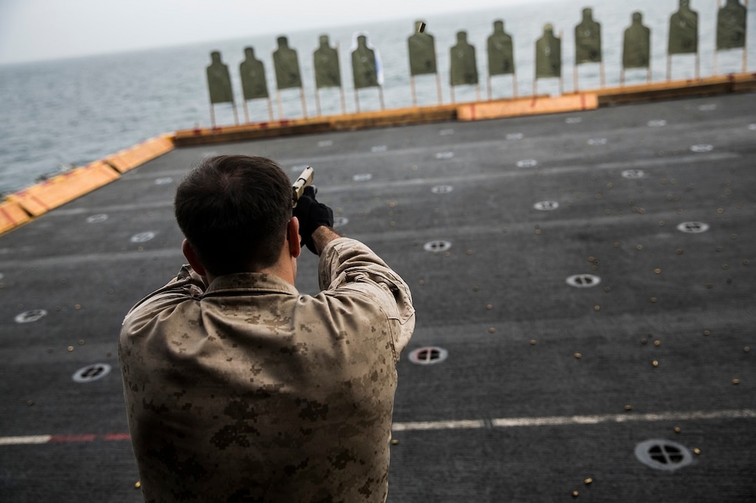 INDIAN OCEAN (Aug. 4, 2015) U.S. Navy Hospital Corpsman 3rd Class Jeremiah Zapata fires at a target with an M45 1911A1 pistol aboard the amphibious assault ship USS Essex (LHD 2). Zapata is a corpsman with the 15th Marine Expeditionary Unit’s Maritime Raid Force security element. These Marines practice slow-fire shooting to enhance their fundamentals and accuracy. The 15th MEU is embarked on the Essex Amphibious Ready Group and deployed to maintain regional security in the U.S. 5th Fleet area of operations. (U.S. Marine Corps photo by Cpl. Anna Albrecht/Released)