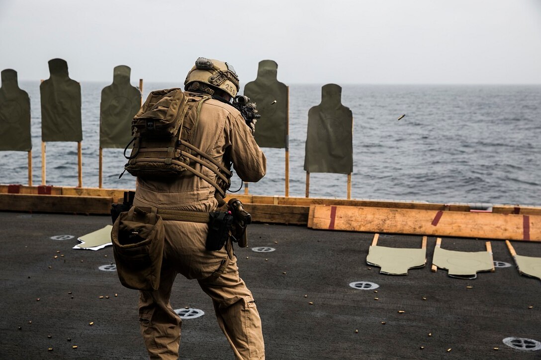 INDIAN OCEAN (Aug. 4, 2015) A U.S. Marine with the 15th Marine Expeditionary Unit’s Maritime Raid Force fires at a target while moving toward cover during a deck shoot aboard the amphibious assault ship USS Essex (LHD 2). These Marines practiced shooting on the move as well as engaging their targets from behind barricades to enhance their marksmanship skills. The 15th MEU is embarked on the Essex Amphibious Ready Group and deployed to maintain regional security in the U.S. 5th Fleet area of operations. (U.S. Marine Corps photo by Cpl. Anna Albrecht/Released)