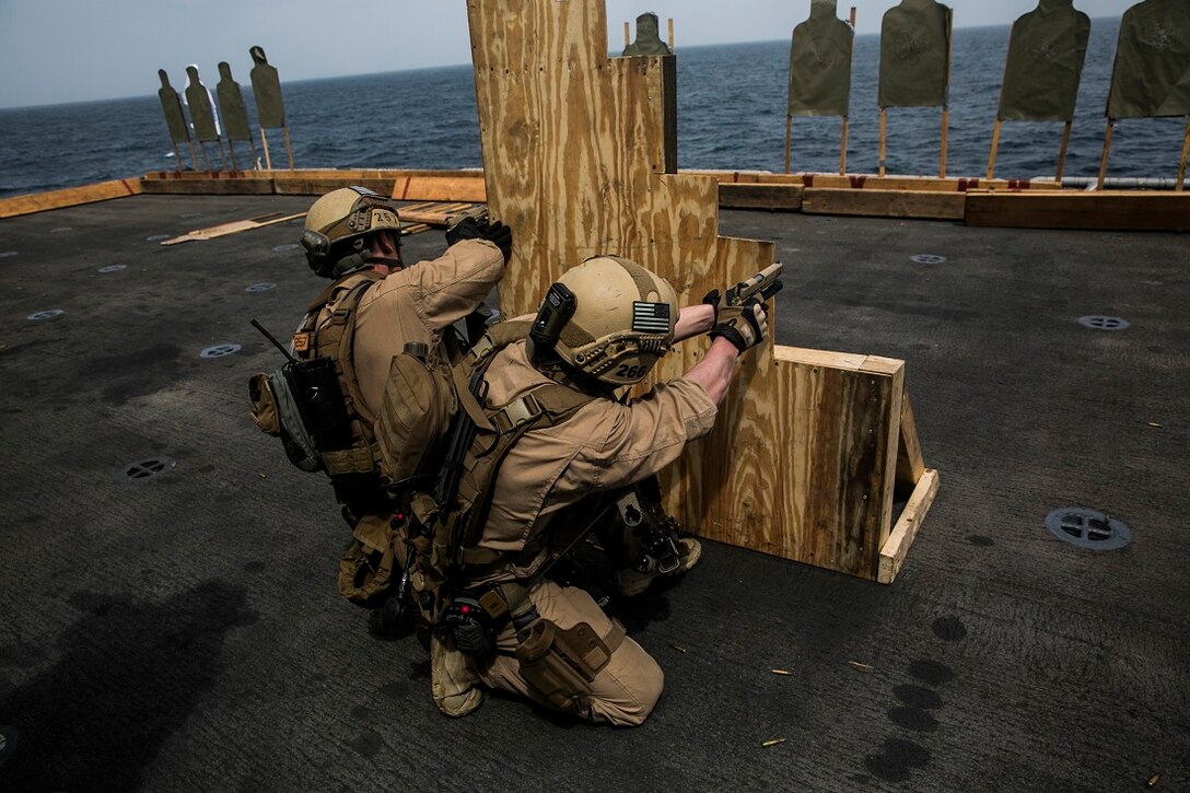 INDIAN OCEAN (August 4, 2015) U.S. Marines with the 15th Marine Expeditionary Unit’s Maritime Raid Force fire at targets from behind a barricade during a deck shoot aboard the amphibious assault ship USS Essex (LHD 2). These Marines practiced maneuvering as buddy teams to different sources of cover to enhance their marksmanship skills. The 15th MEU is embarked on the Essex Amphibious Ready Group and deployed to maintain regional security in the U.S. 5th Fleet area of operations. (U.S. Marine Corps photo by Cpl. Anna Albrecht/Released)