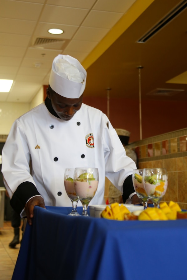 Cpl. Djeela Anderson brings judges her selected menu during the Chef of the Quarter competition at Marine Corps Air Station Cherry Point, N.C., Aug. 6, 2015. Two Marines with Headquarters and Headquarters Squadron and one Marine with Marine Wing Support Squadron 274 put their skills to the test as they were judged on presentation, taste, bearing and their food service knowledge during the event. The competition allows Marines to use their creativity to prepare meals rather than their routine menus at the galley.
