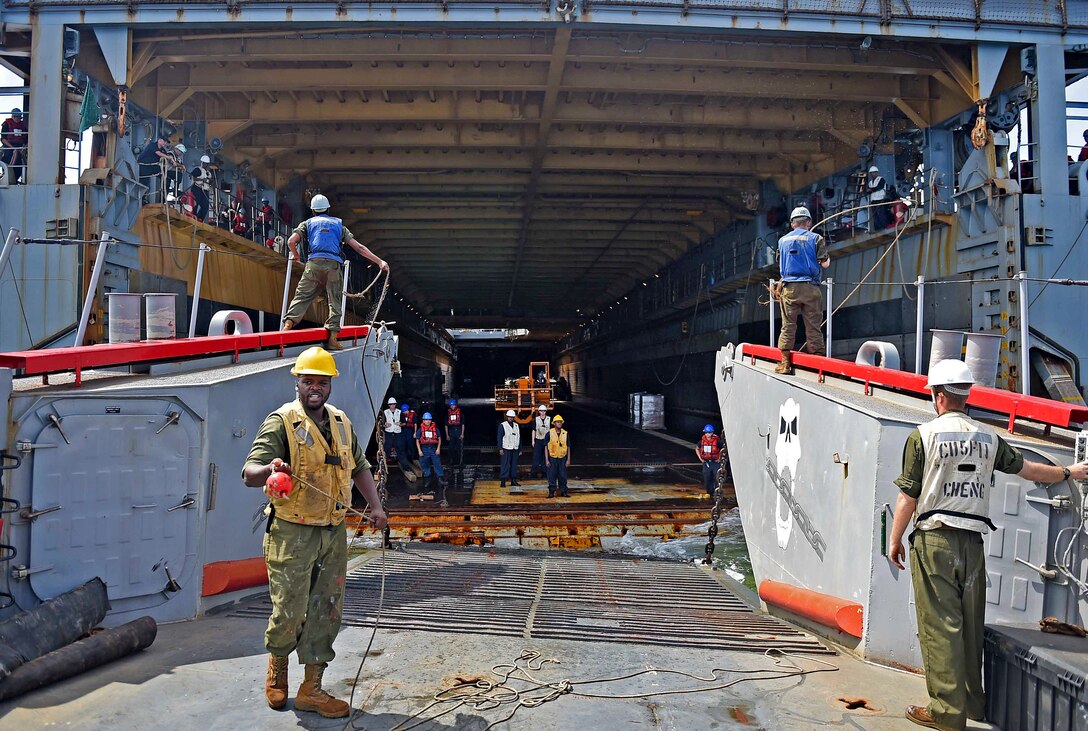 U.S. sailors on Landing Craft Utility 7 attached to Naval Beach Unit 7 conduct a sterngate marriage to the well deck of the amphibious dock landing ship USS Ashland at Apra Harbor, Guam, Aug. 10, 2015. 