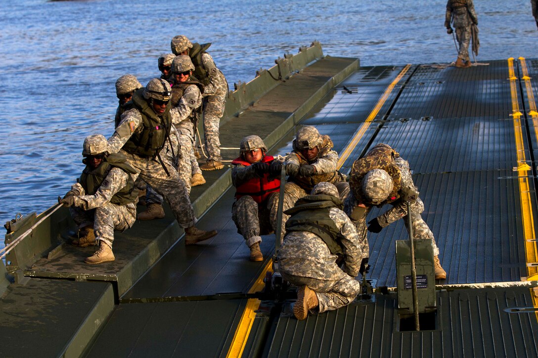 Soldiers assemble a pair of interior bridge bays on the Arkansas River during Operation River Assault 2015 at Fort Chaffee, Ark., Aug. 4, 2015. 