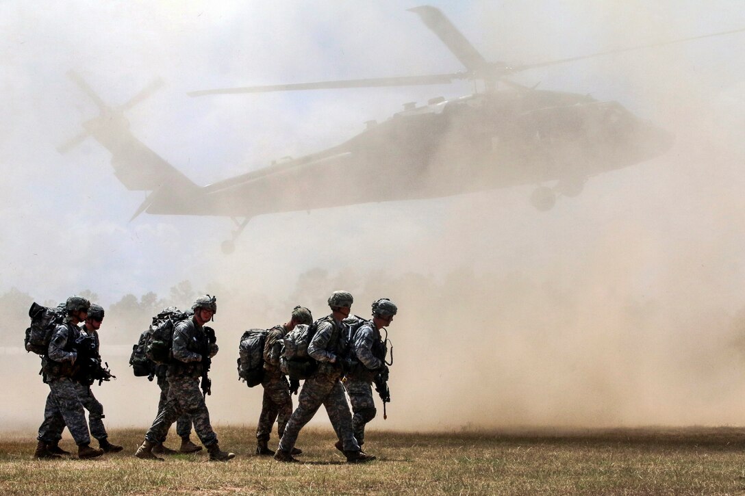 Paratroopers move to their loading zone as rotor wash from a UH-60 Black Hawk helicopter caused a dust cloud during Operation Red Fury on Fort Bragg, N.C., Aug. 4, 2015. The training helped to increase the unit’s interoperability between ground and aviation units. The paratroopers are assigned to the 82nd Airborne Division's 1st Battalion, 508th Parachute Infantry Regiment, 2nd Brigade Combat Team.