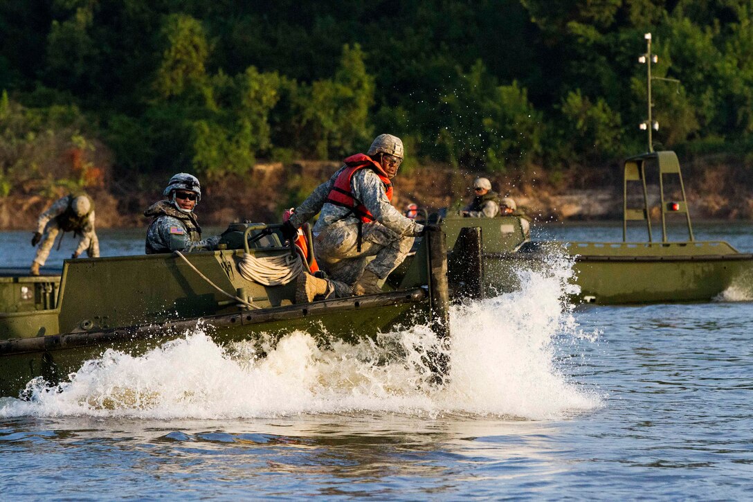Soldiers maneuver a bridge erection boat to retrieve a bridge bay for assembly on the Arkansas River during Operation River Assault 2015 at Fort Chaffee, Ark., Aug. 4, 2015.
