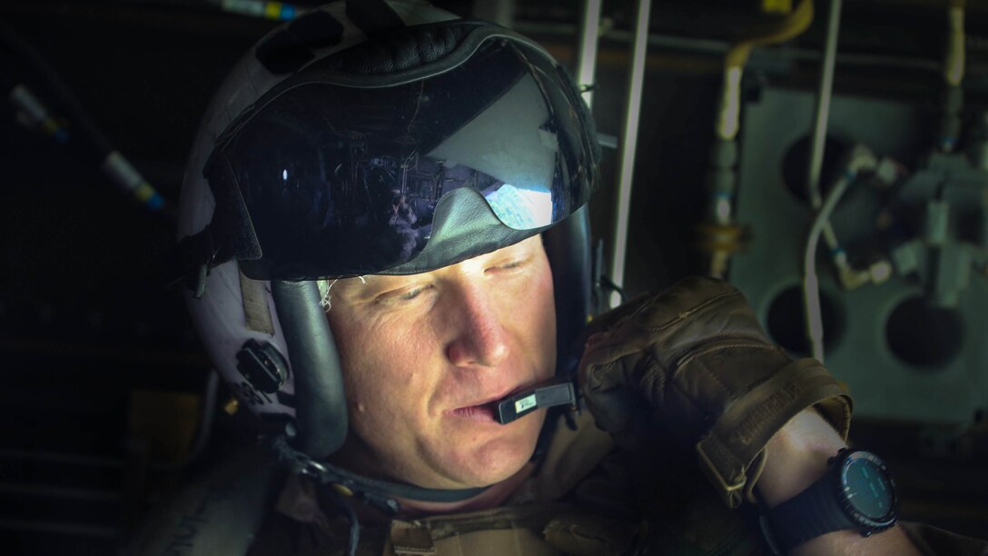 Corporal Chris Stewart, the senior crew chief aboard an MV-22B Osprey aircraft with Marine Medium Tiltrotor Squadron 365 (Reinforced), communicates with pilots during a para-operations training with an 2nd Reconnaissance Battalion aboard Camp Lejeune, N.C., Aug. 6, 2015. Reconnaissance Marines, rigged with parachutes, jumped from an altitude of 13,000 feet with the assistance of Marines with VMM-365 (Rein) to practice the airborne insertion. 