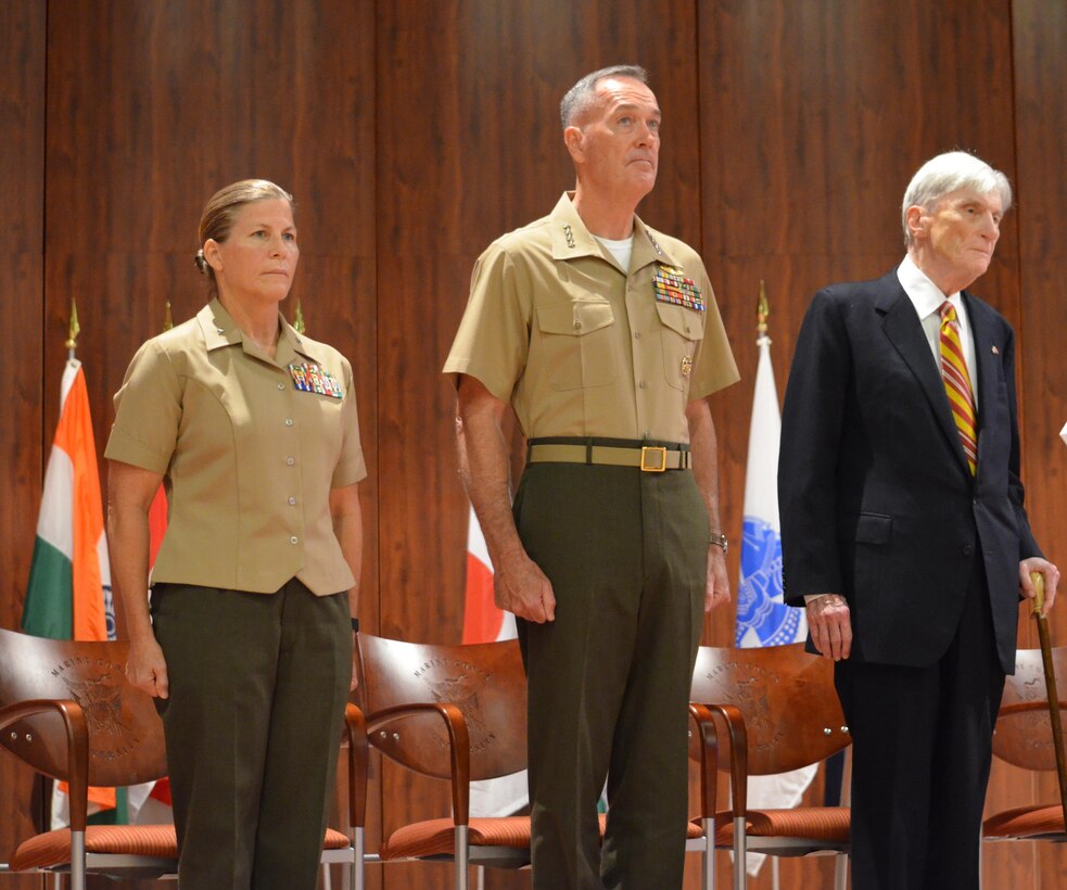 Brig. Gen. Helen Pratt, president of Marine Corps University; Gen. Joseph Dunford, commandant of the Marine Corps; and Sen. John Warner stand at attention for the playing of the service hymns during the Aug. 7 ceremony dedicating the new MCU building in Warner’s name.