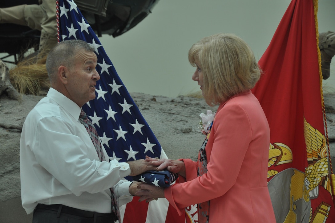 Deborah J. Summers is presented with a U.S. flag by Micheal F. Applegate, director of Manpower and Reserve Affairs Dept. Headquarters, during her retirement ceremony at the National Museum of the Marine Corps, Aug. 6. The flag was flown over the Marine Corps War Memorial. Today the memorial is a symbol of the nation's esteem for the honored fallen Marines since 1785