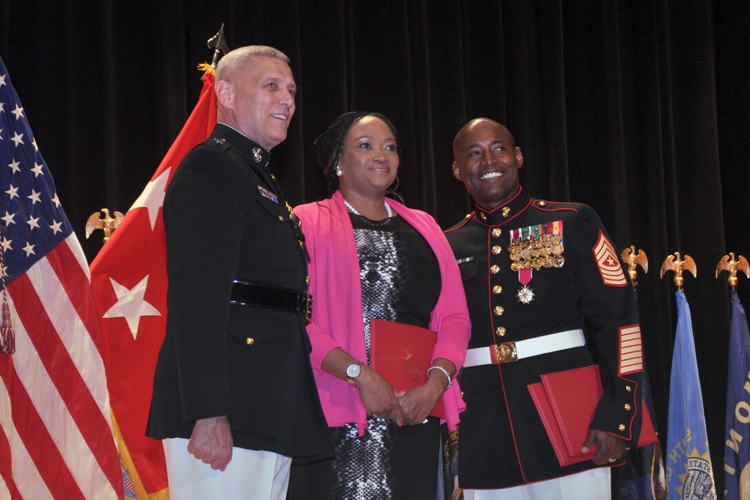 General John M. Paxton Jr., assistant commandant of the Marine Corps, honors Sgt. Maj. Mark A. Byrd Sr., and his wife Tora L. Byrd, during a retirement ceremony at the Little Hall Theater, Friday.