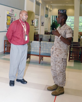 Col. James C. Carroll III, commanding officer, Marine Corps Logistics Base Albany, addresses Vincent Hairston, medical support assistant, Veterans Affairs Community-Based Outpatient Clinic, at the clinic housed aboard MCLB Albany, Aug. 7. Hairston  provided outstanding customer service to a veteran in need of around-the-clock care. 