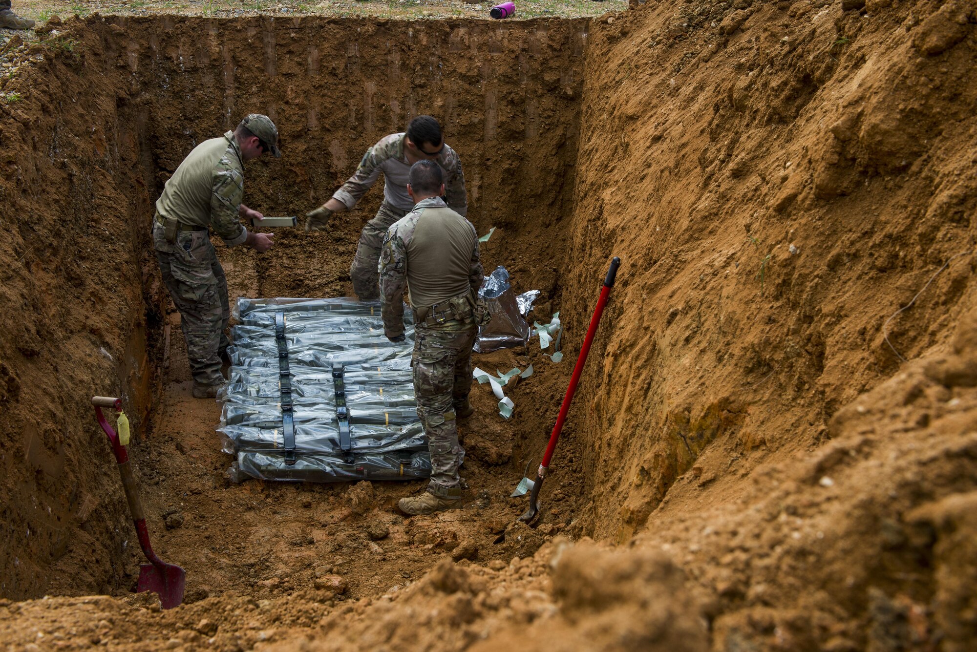 Members of the 18th Civil Engineer Squadron Explosive Ordnance Disposal Flight place C-4 explosives on unserviceable munitions to destroy them on Kadena Air Base, Japan Aug. 12, 2015. The 18th CES EOD Flight continues to keep Okinawans, service members and families safe by recovering UXOs that are hazardous. (U.S. Air Force photo by Senior Airman Stephen G. Eigel)