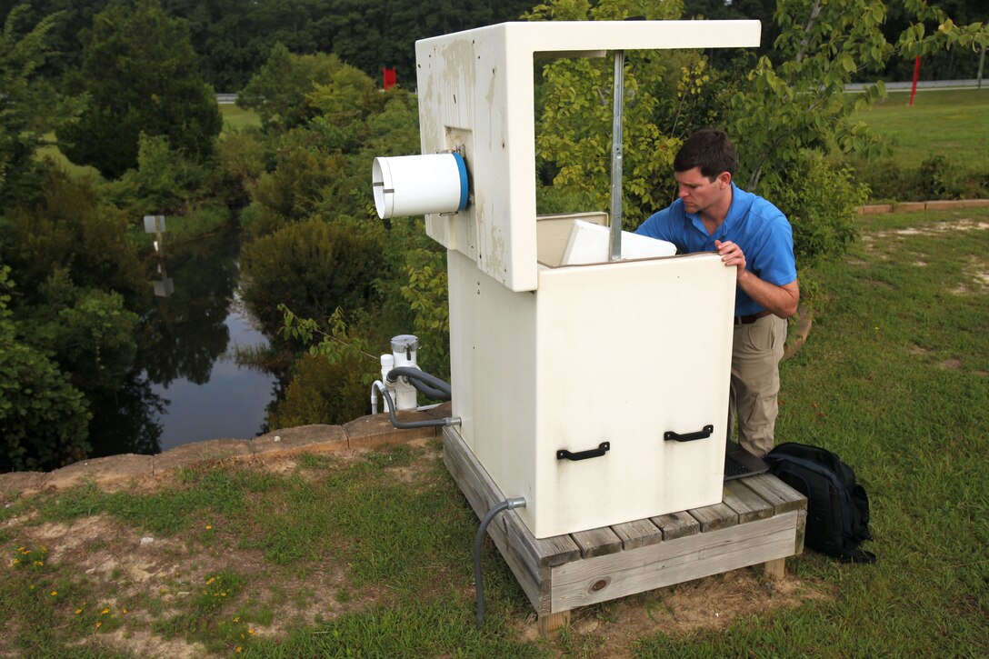 Judah Emory extracts data from a stormwater monitoring outfall site at Marine Corps Air Station Cherry Point, North Carolina, July 31, 2015. The site is one of five outfalls that monitor the water quality aboard the installation. The site directly discharges into Slocum Creek and is a part of the Neuse River Basin. Emory is an environmental engineer with the Cherry Point Environmental Affairs Department.