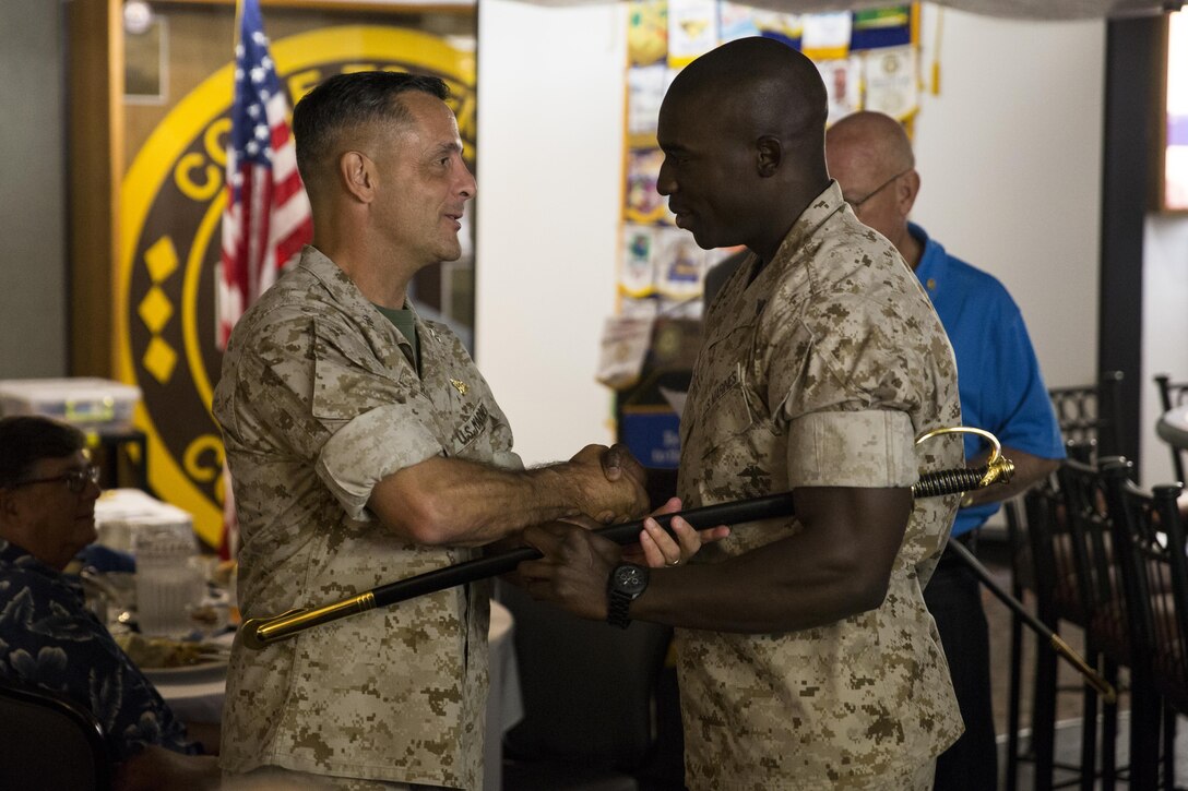 Maj. Gen. Michael Rocco, left, commanding general of 3rd Marine Aircraft Wing, presents an noncommissioned officer (NCO) sword to Cpl. Demetri Brown, an airframes mechanic with Marine Tilitrotor Squadron (VMM) 268, during a Miramar Semper Fidelis Rotary Foundation meeting aboard Marine Corps Air Station Miramar, California, Aug. 6. Rocco emphasized the importance of noncommissioned officers in 3rd MAW at the end of the meeting. (U.S. Marine Corps photo by Cpl. Michael Thorn/Released)
