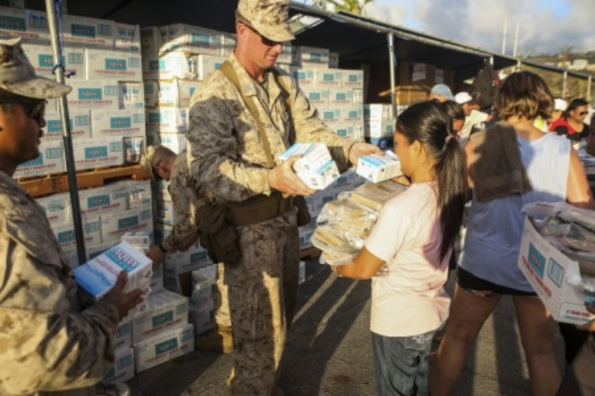 Marines hand out water to the residents of Saipan