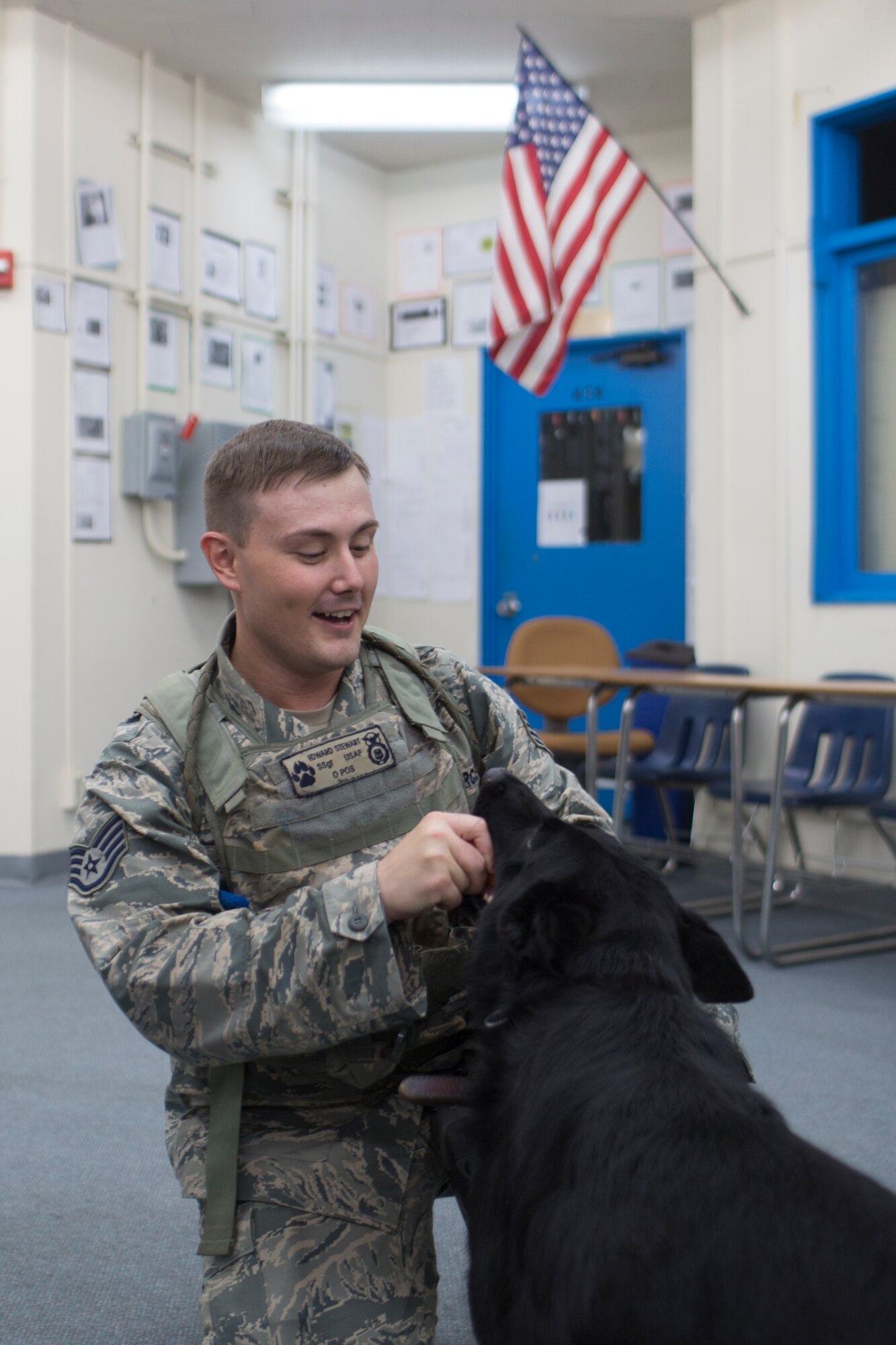 Staff Sgt. Edward Stewart, 374th Security Forces Squadron military working dog handler, praises Stella, 374th SFS military working dog, after completing a training session at Yokota Air Base, Japan, Aug. 6, 2015. Yokota’s MWD section is trained in environments mirroring every predictable real-world scenario. (U.S. Air Force photo by Osakabe Yasuo/Released) 