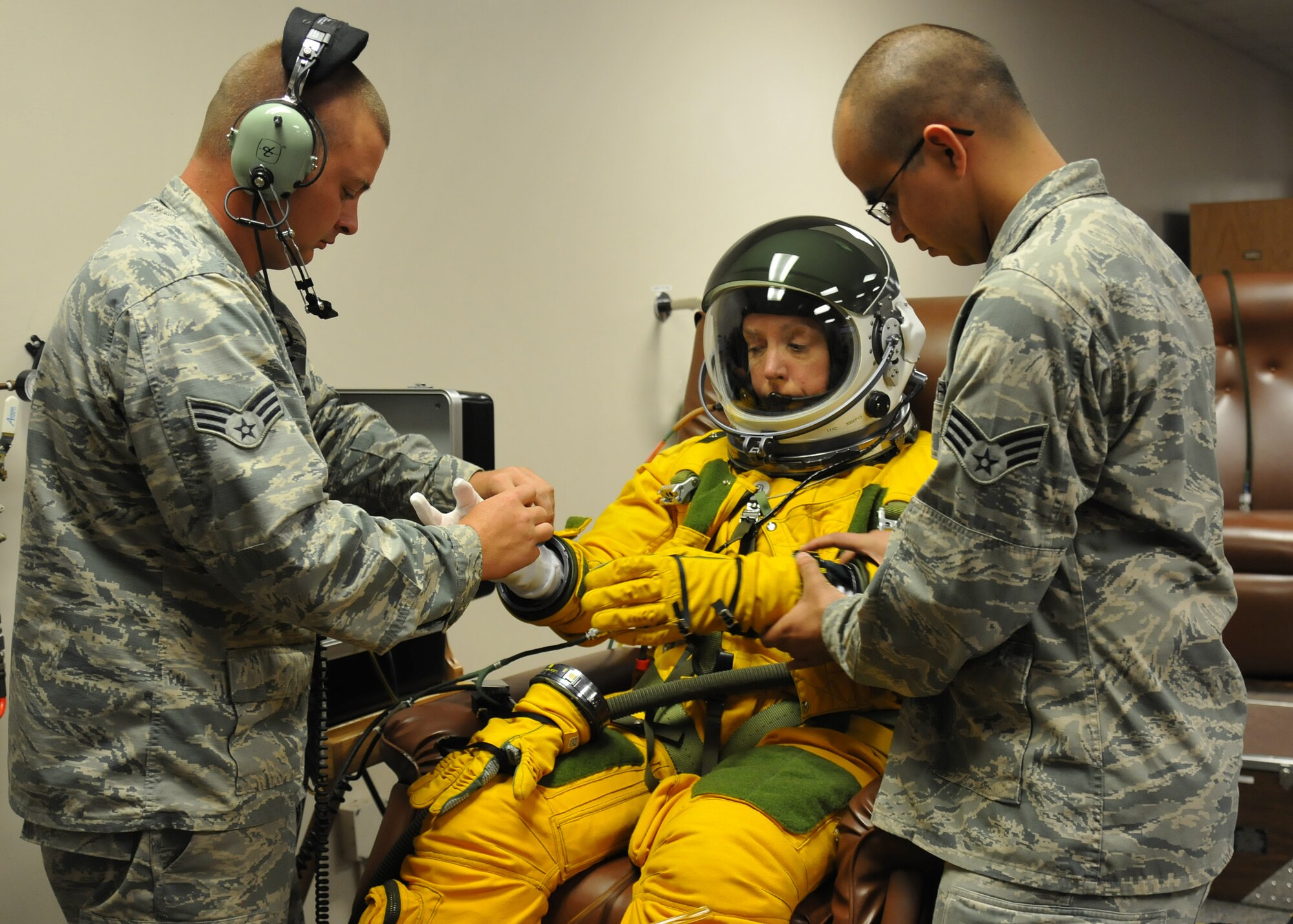 Senior Airmen Kyle Lang (right) and Aaron Saenz (left), 9th Physiological Support Squadron launch and recovery technicians, help Secretary of the Air Force Deborah Lee James properly dress in a high-altitude pressure suit at Beale Air Force Base, California, Aug. 11, 2015.  The specialized pressure suit allows U-2 Dragon Lady pilots to safely fly at altitudes reaching 70,000 feet. James visited Beale to receive a first-hand perspective of high-altitude intelligence, surveillance and reconnaissance from collection to dissemination. (U.S. Air Force photo by Senior Airman Dana J. Cable)
