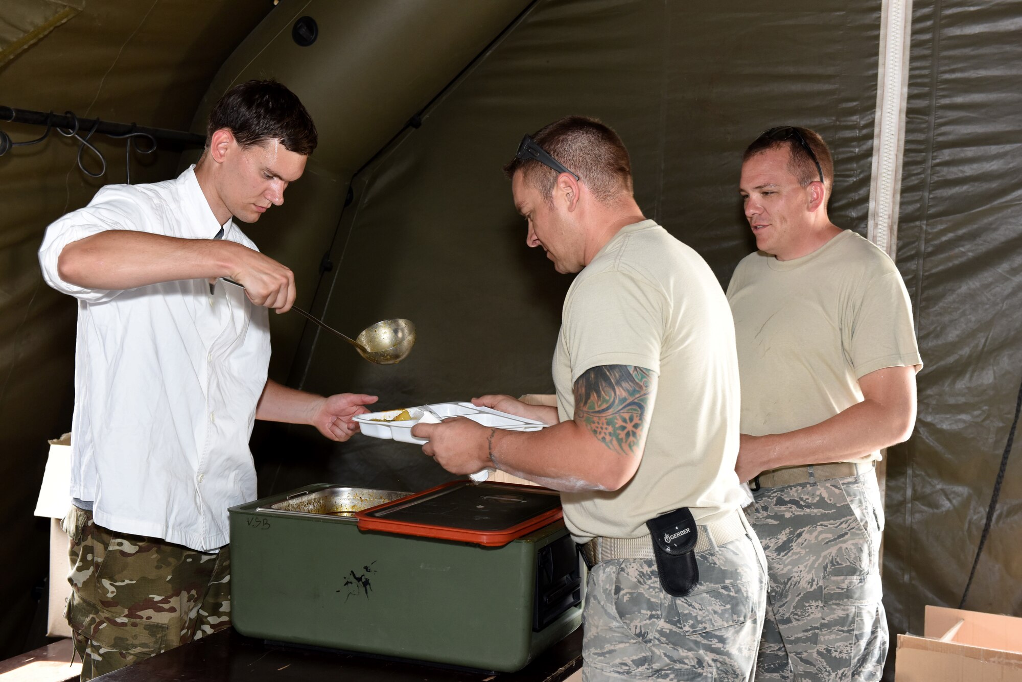 U.S. Air Force Staff Sgt. Dane Wetterer and Senior Master Sgt. Harry Smith, 233d Space Communications Squadron, Colorado Air National Guard (COANG) are served lunchby a member of the Slovenian Armed Forces (SAF) at Pocek Range, near Postonja, Slovenia, July 24, 2015. The COANG is on a deployed for training mission to upgrade the current Slovenian range facility with more enhanced capabilities that will be able to conduct multinational training for on ground and air-to-ground tactics in the European theater. (U.S. Air National Guard photo by Senior Airman Michelle Y. Alvarez-Rea/Released)