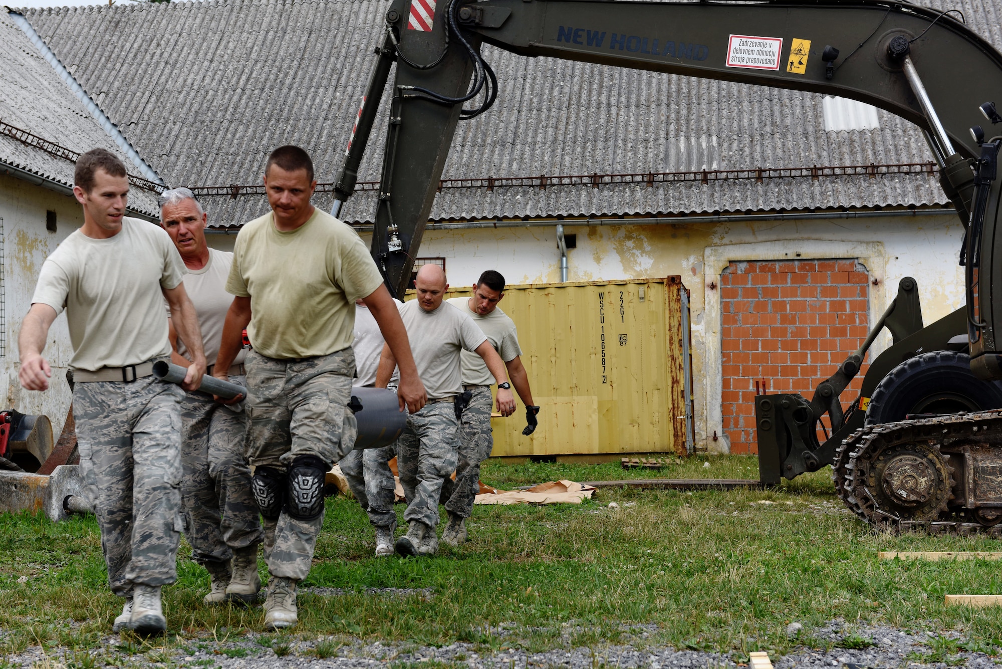 Members of the 140th Civil Engineer Squadron, Colorado Air National Guard (COANG) carry a roll of industrial floor vinyl into a barn at Pocek Range, near Postonja, Slovenia, July 23, 2015. The COANG is on a deployed for training mission as part of the Colorado State Partnership Program (SPP), revamping a historically old barn into a range center facility to conduct multinational training for on ground and air-to-ground tactics in the European theater. The SPP is focused on building relationships while supporting one another and improving the strategic objectives of both countries. (U.S. Air National Guard photo by Senior Airman Michelle Y. Alvarez-Rea/Released)