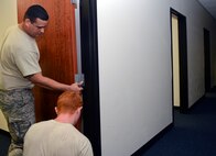 Tech. Sgt. Luis Garcia-Alvarez, left, and Staff Sgt. Calvin Myers, 22nd Civil Engineer Squadron structural craftsmen, install a door in Bldg. 1219 Aug. 11, 2015, at McConnell Air Force Base Kan. The 22nd CES spent four months renovating the building turning it into the new alert facility. (U.S. Air Force photo by Senior Airman Colby L. Hardin)
