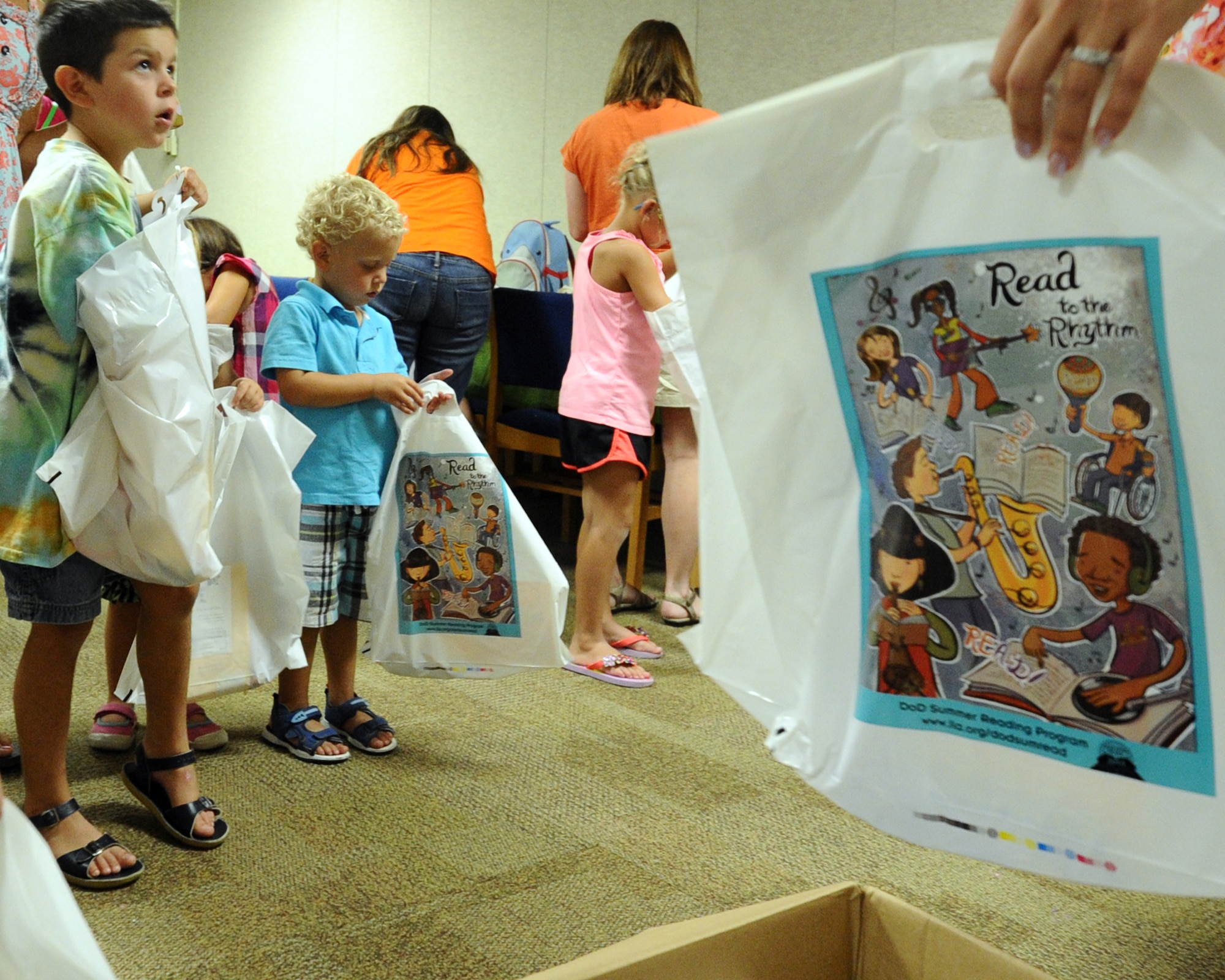 Library technicians hand out bags of toys to children at the Tyndall base library during the Read to the Rhythm program July 29. Read to the Rhythm is a program targeted to develop verbal and reading skills of children sponsored by the 325th Force Support Squadron. (U.S. Air Force photo by Senior Airman Ty-Rico Lea/Released)